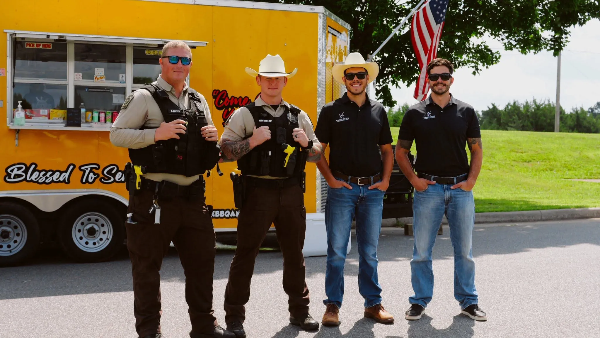 Daniel Wright and crew with sheriff's deputies in front of a yellow food truck