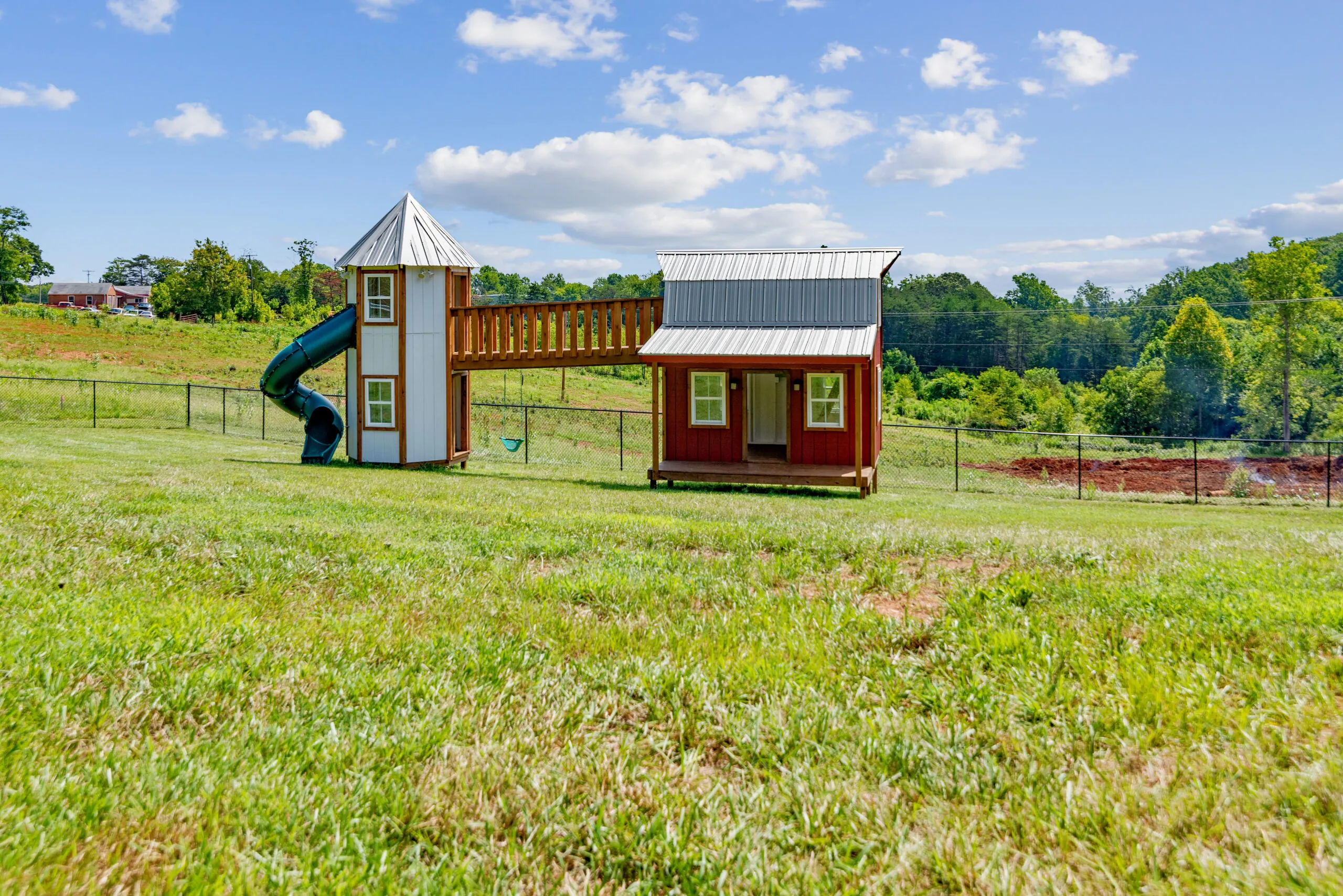 Red playhouse with tower slide in the yard of the Lowry Home