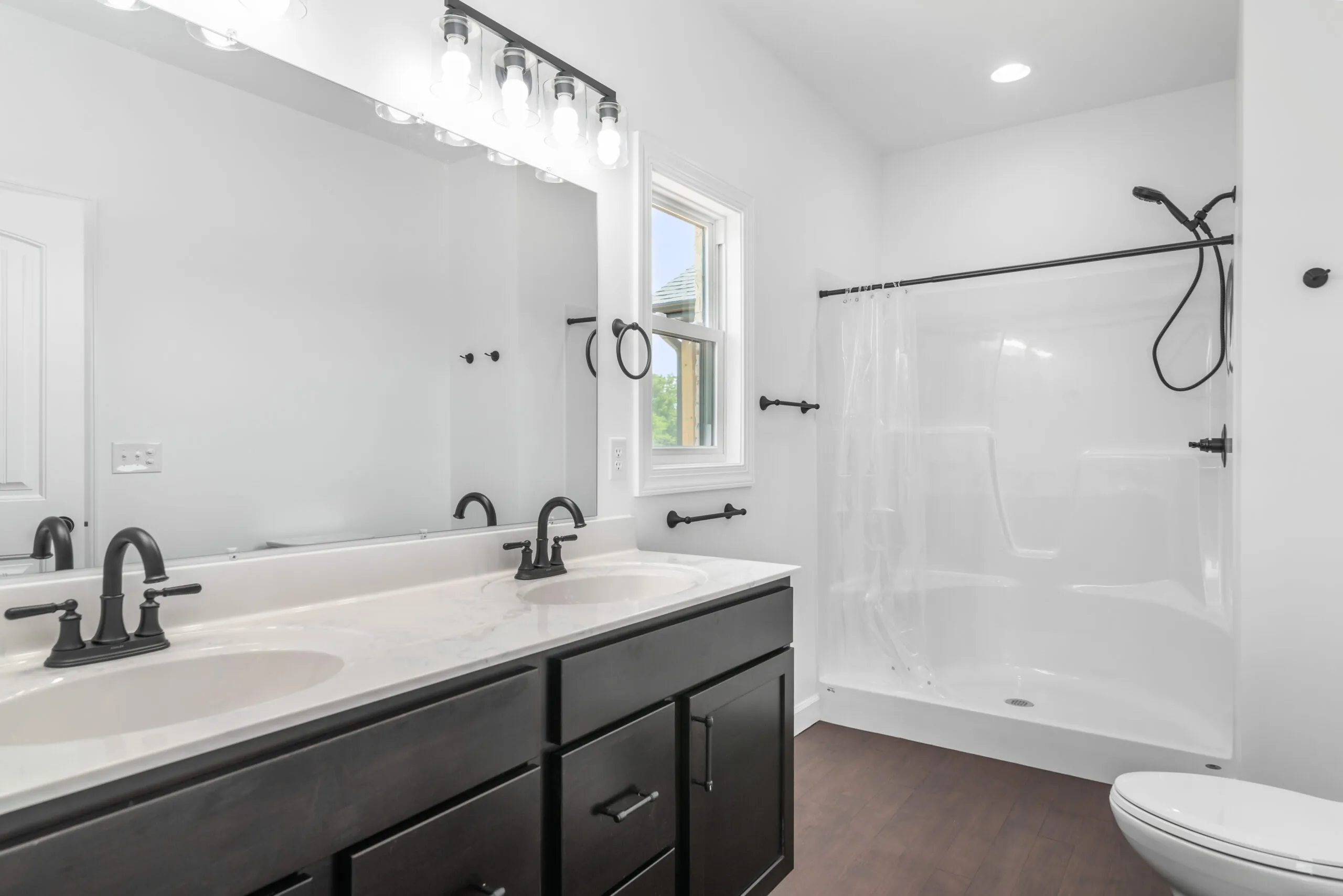 Bathroom with dark double vanity and shower in the Otterlea Home