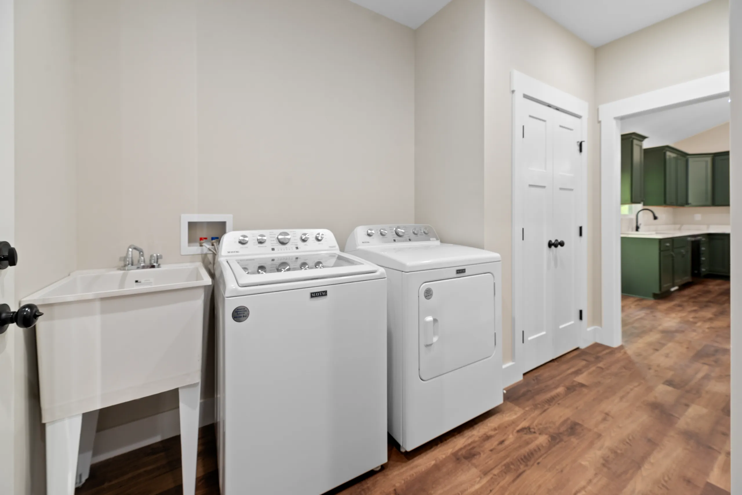 Laundry room with washer, dryer and utility sink in the Lake Crest Home