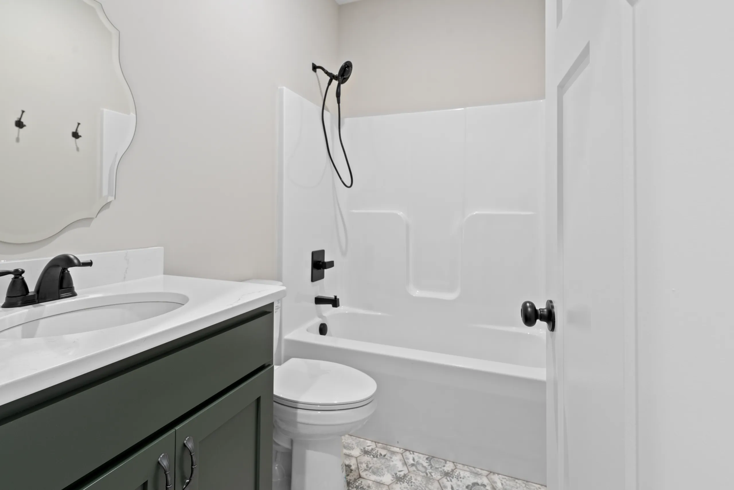 Bathroom with green vanity and tub-shower in the Lake Crest Home