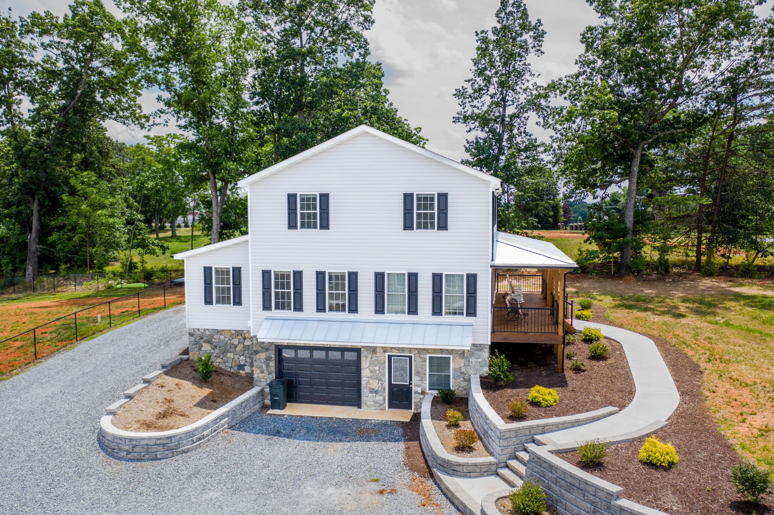 Aerial view of the Timber Ridge Home side with stone foundation and garage