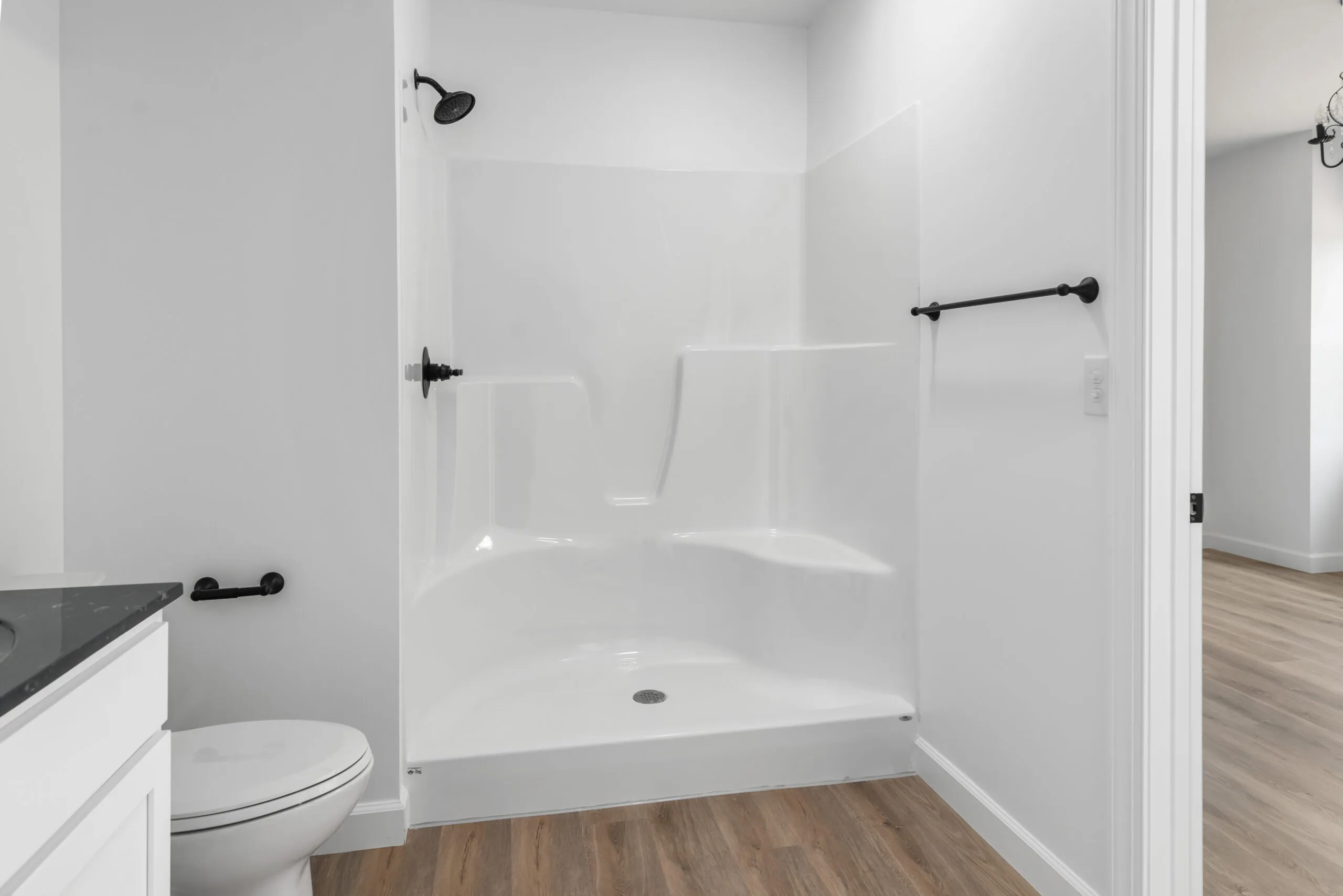 Shower stall with black fixtures in a bathroom in the Otterlea Home