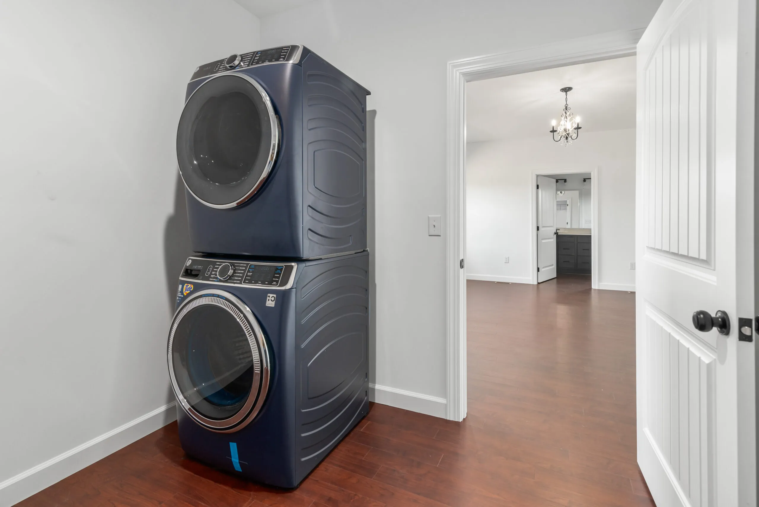 Stacked blue washer and dryer in a laundry closet in the Otterlea Home