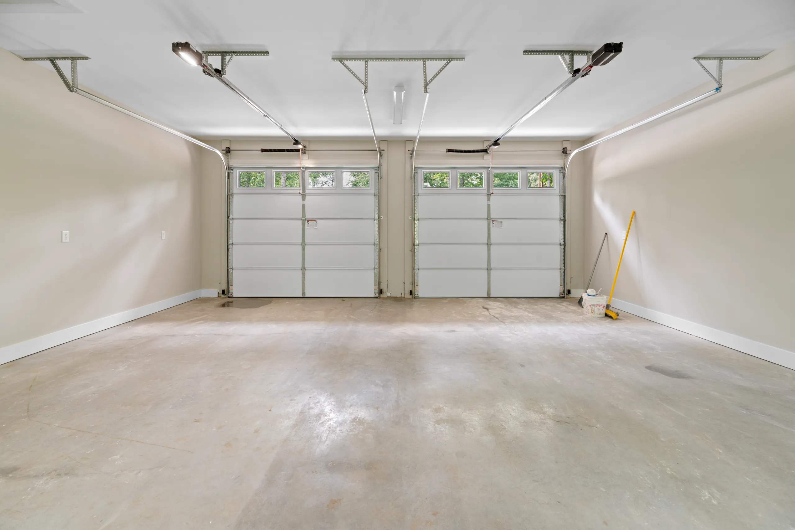 Interior of the two-bay garage with white doors in the Lake Crest Home