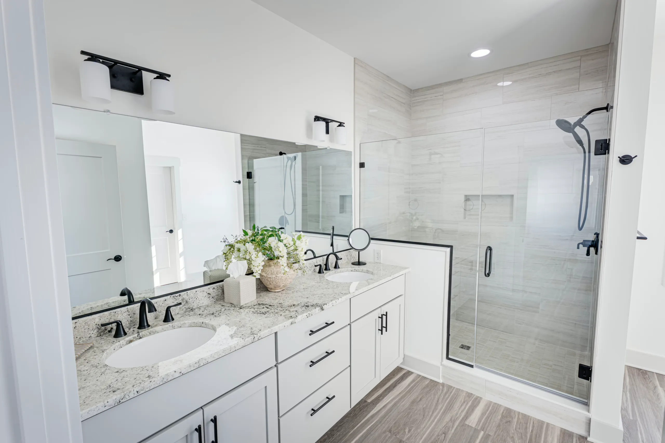 Primary bathroom with double vanity and glass shower in the Powell Lane Home