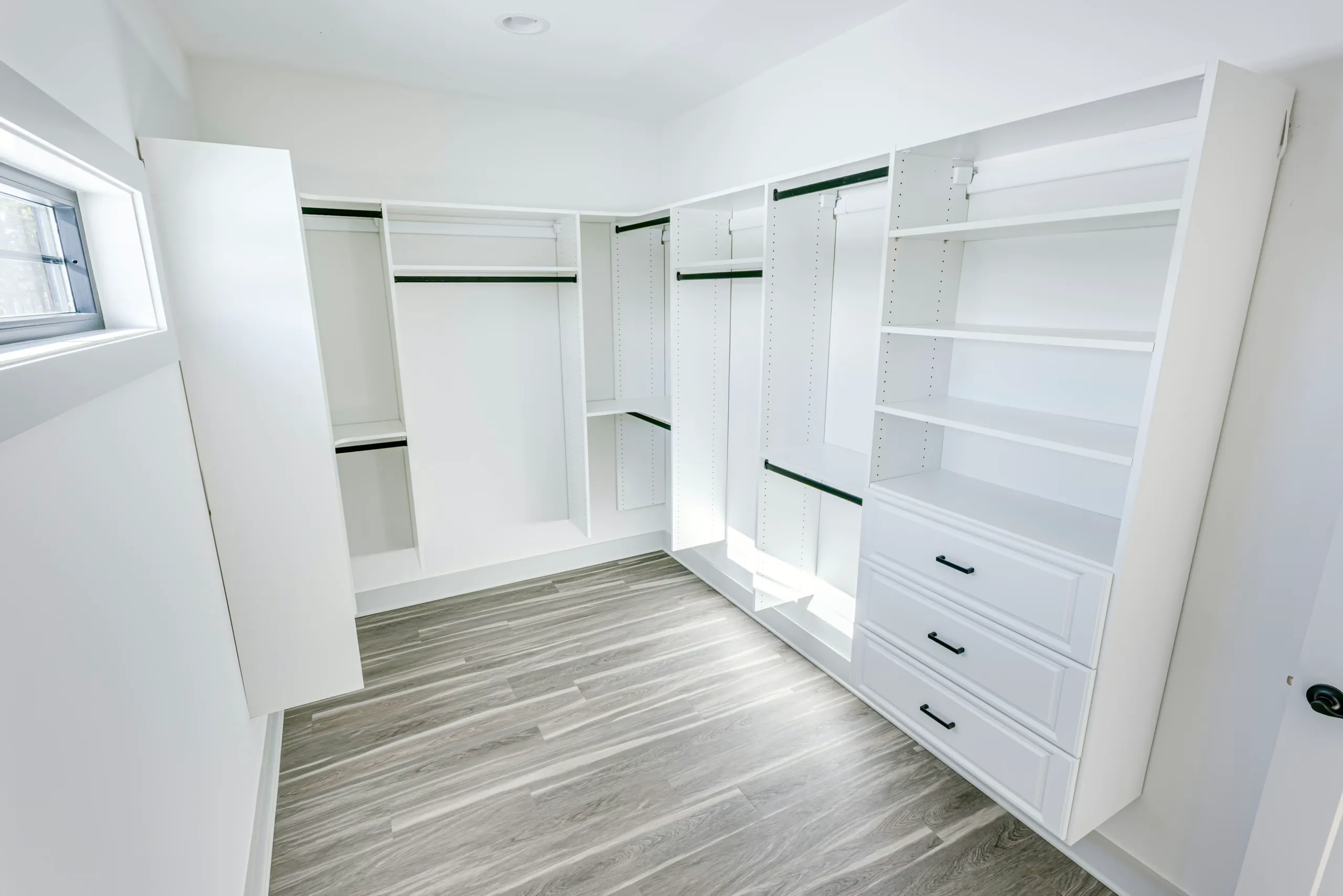 Walk-in primary closet with built-in white shelving in the Powell Lane Home