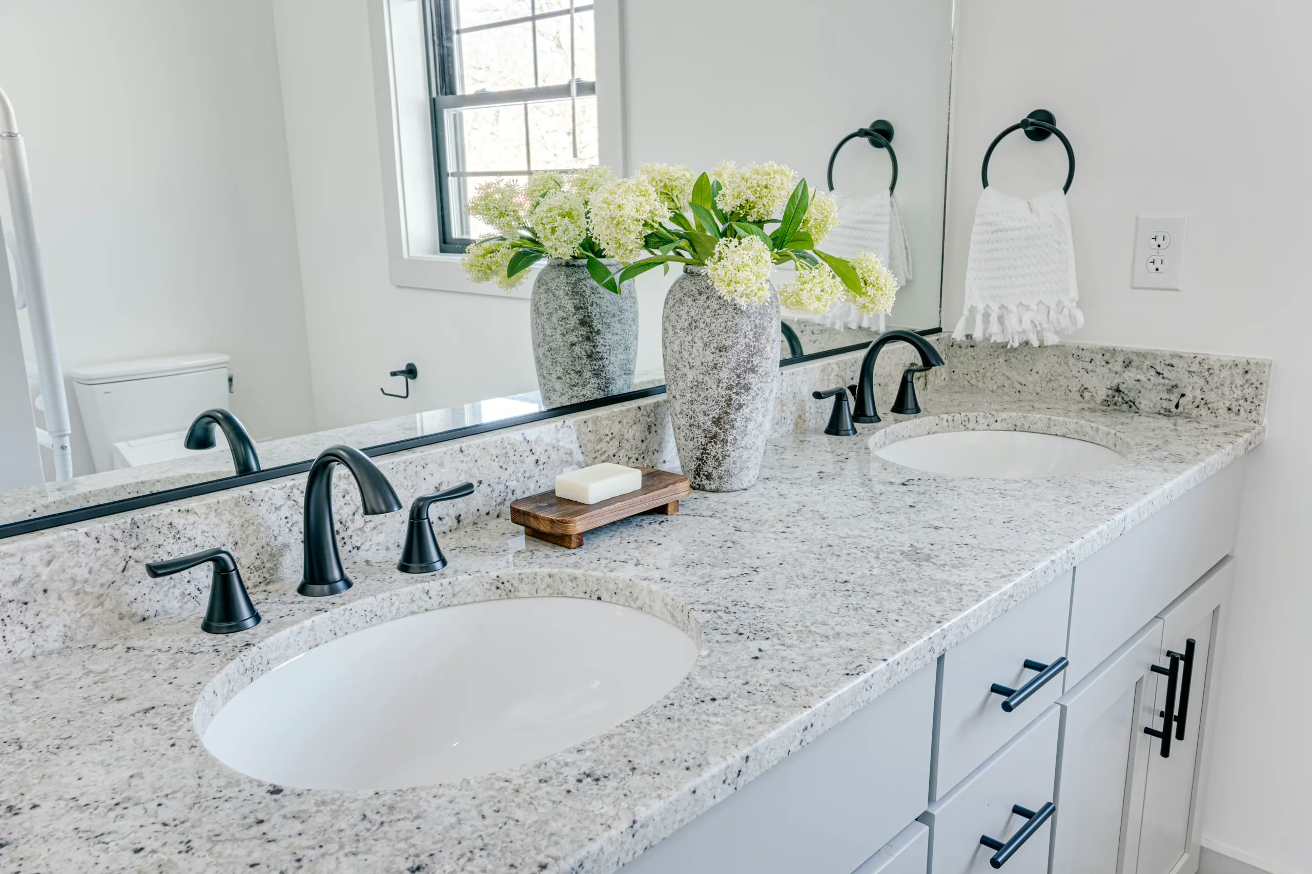 Granite double-sink vanity with black faucets in the Powell Lane Home