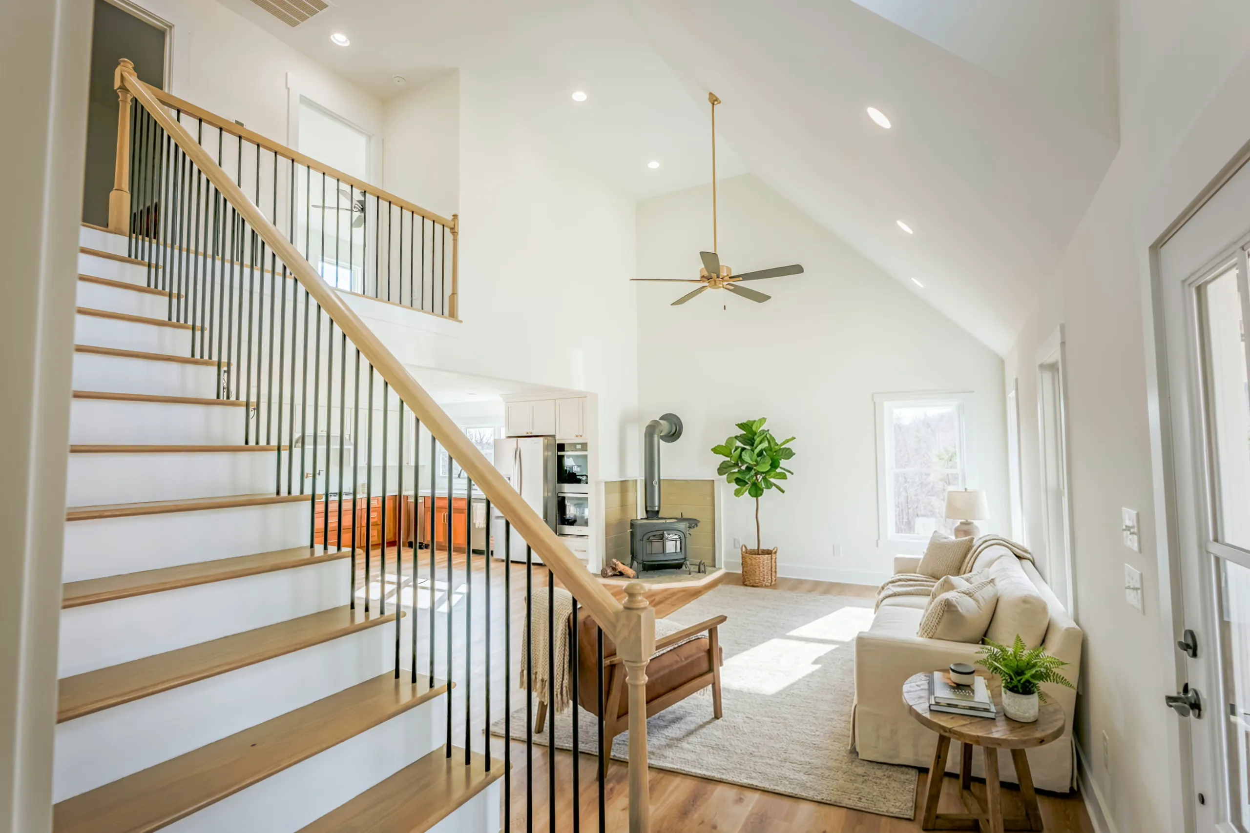 Staircase and vaulted living room with wood stove in the Meaders Mill Home
