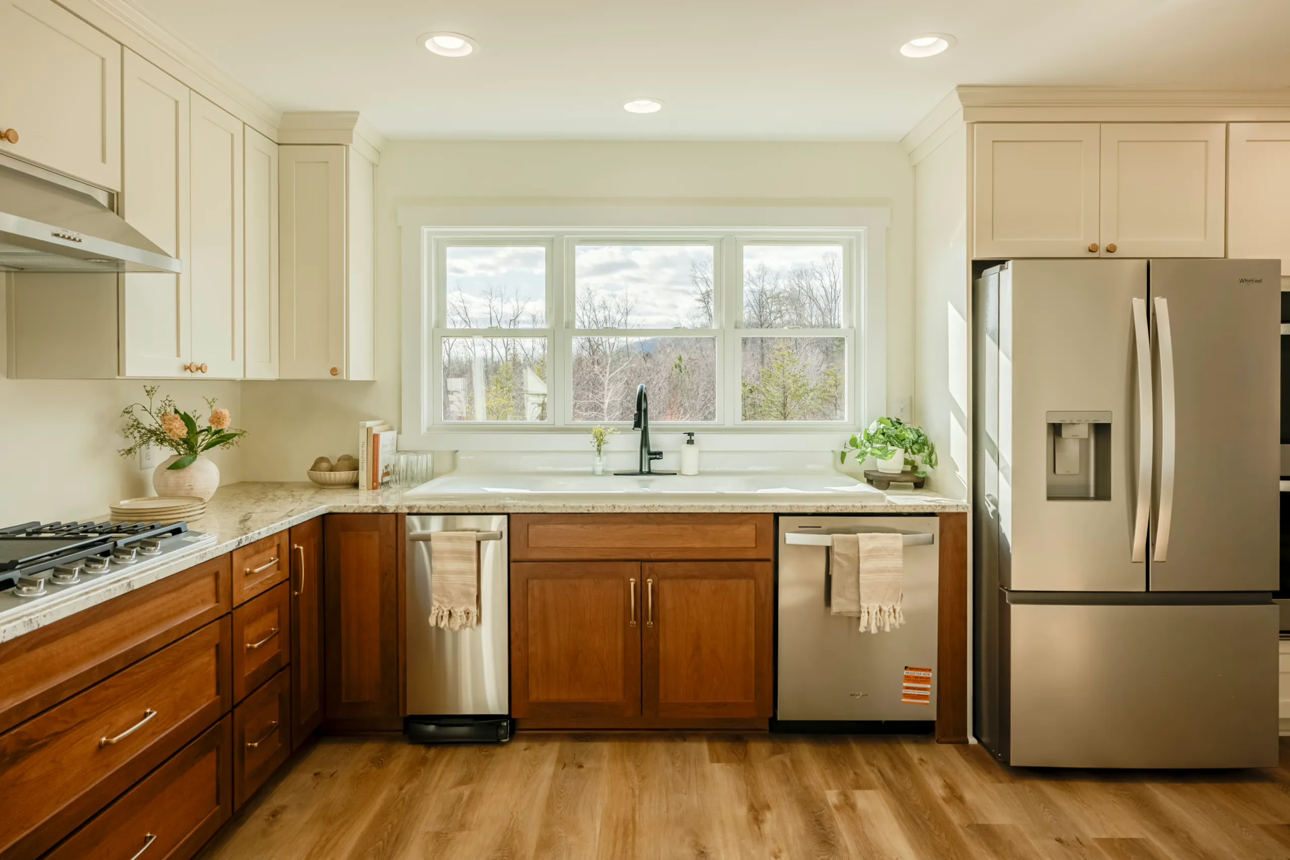 Kitchen with wood cabinets, double sink and window in the Meaders Mill Home