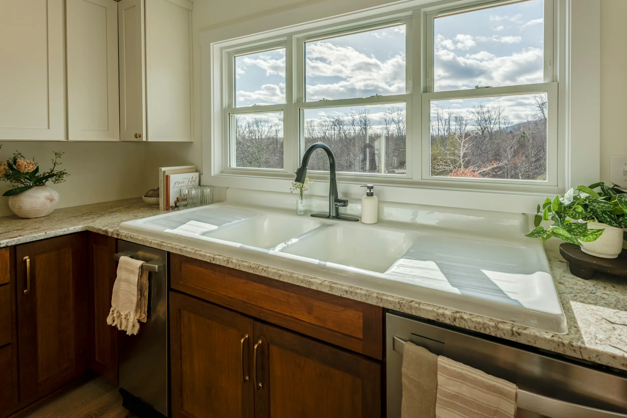 Double kitchen sink beneath a wide window with mountain view in the Meaders Mill Home