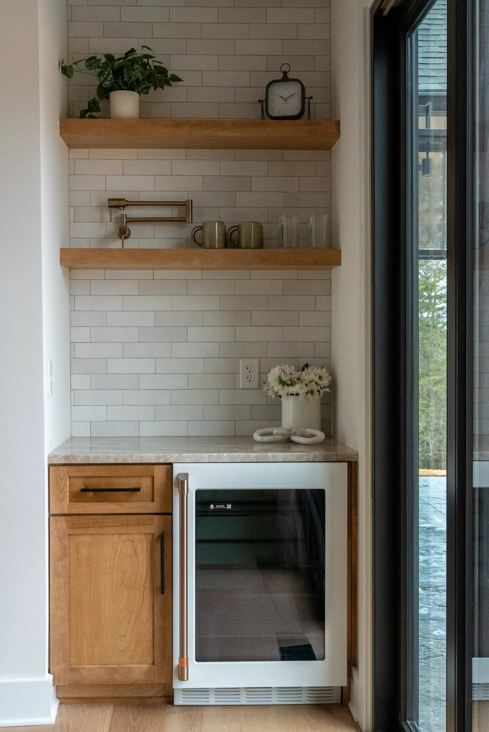 Wet bar nook with wine fridge and floating shelves in the Magnolia Home