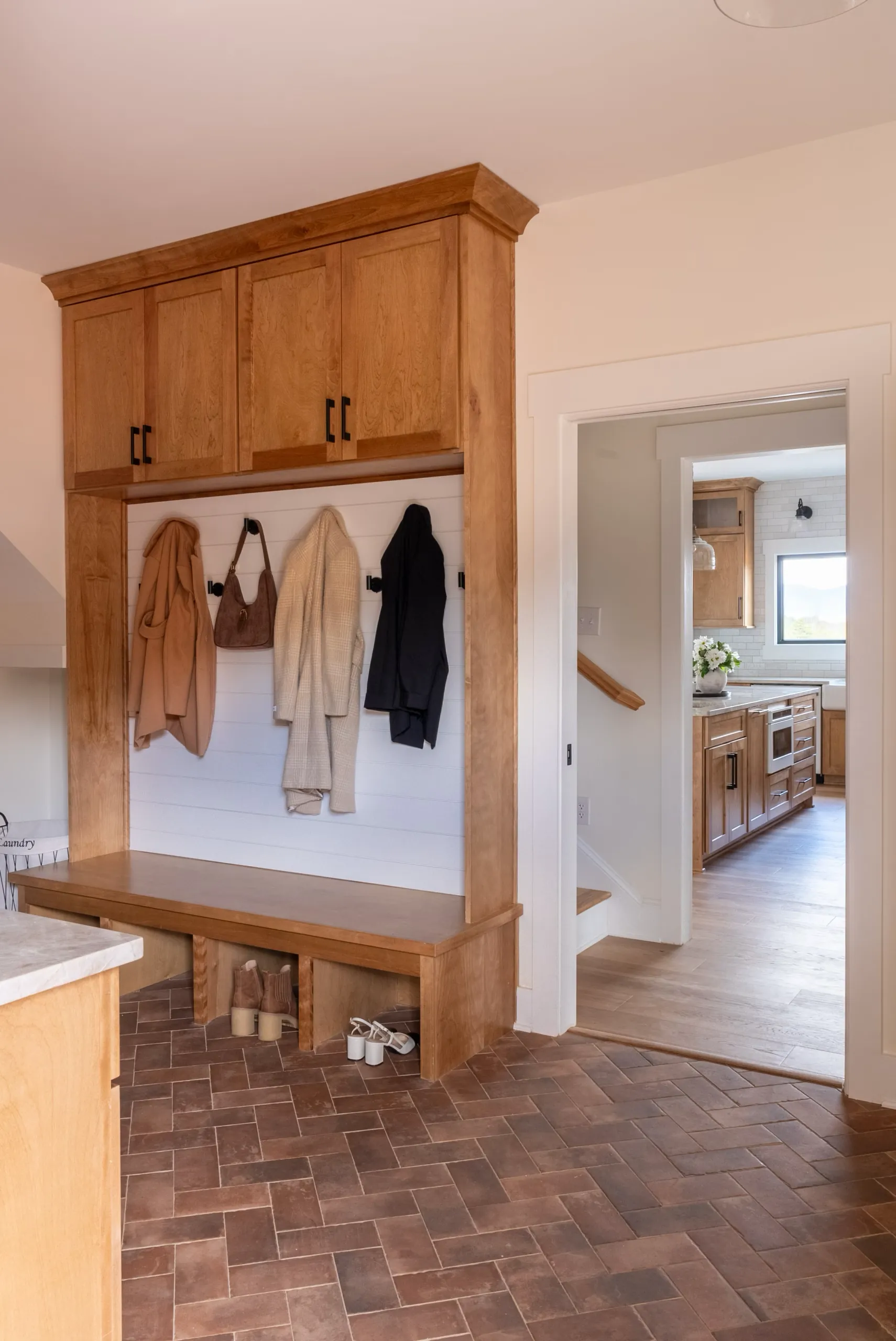 Mudroom with wood cabinets, coat hooks and bench in the Magnolia Home