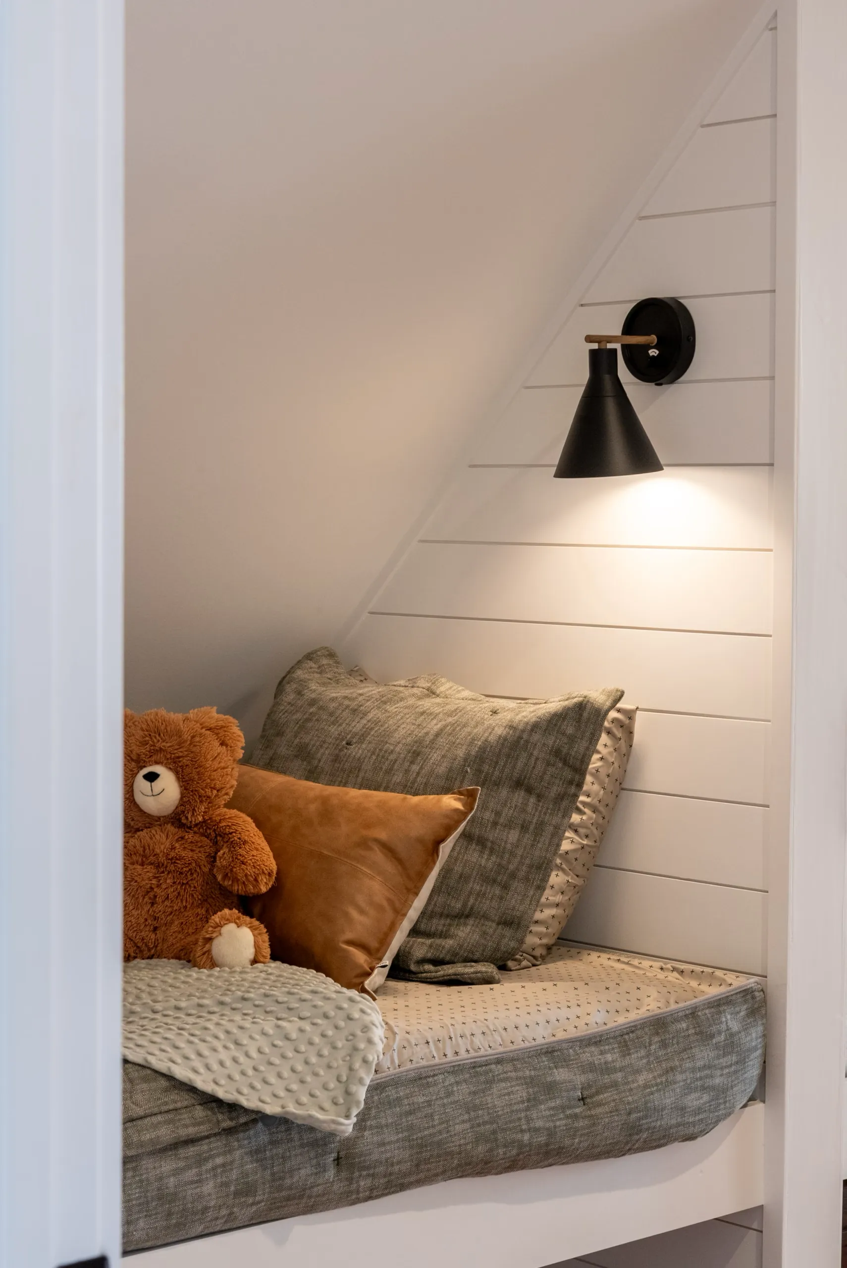 Built-in bed nook with shiplap wall and sconce in the Magnolia Home