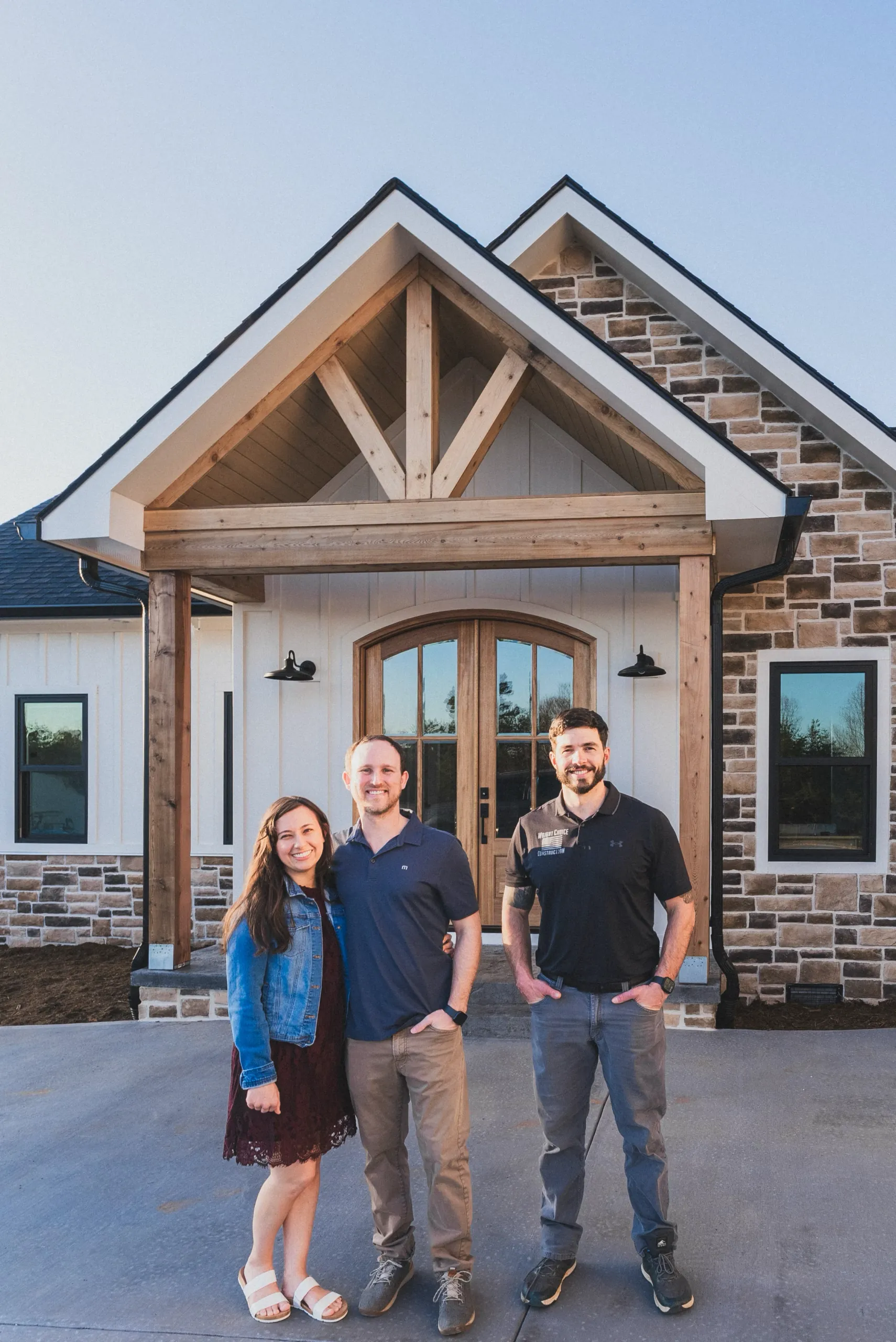 The happy homeowners of the Magnolia Home, and Chief Project Officer John Wright, standing together in front of their beautiful newly built custom home, in Thaxton Virginia.