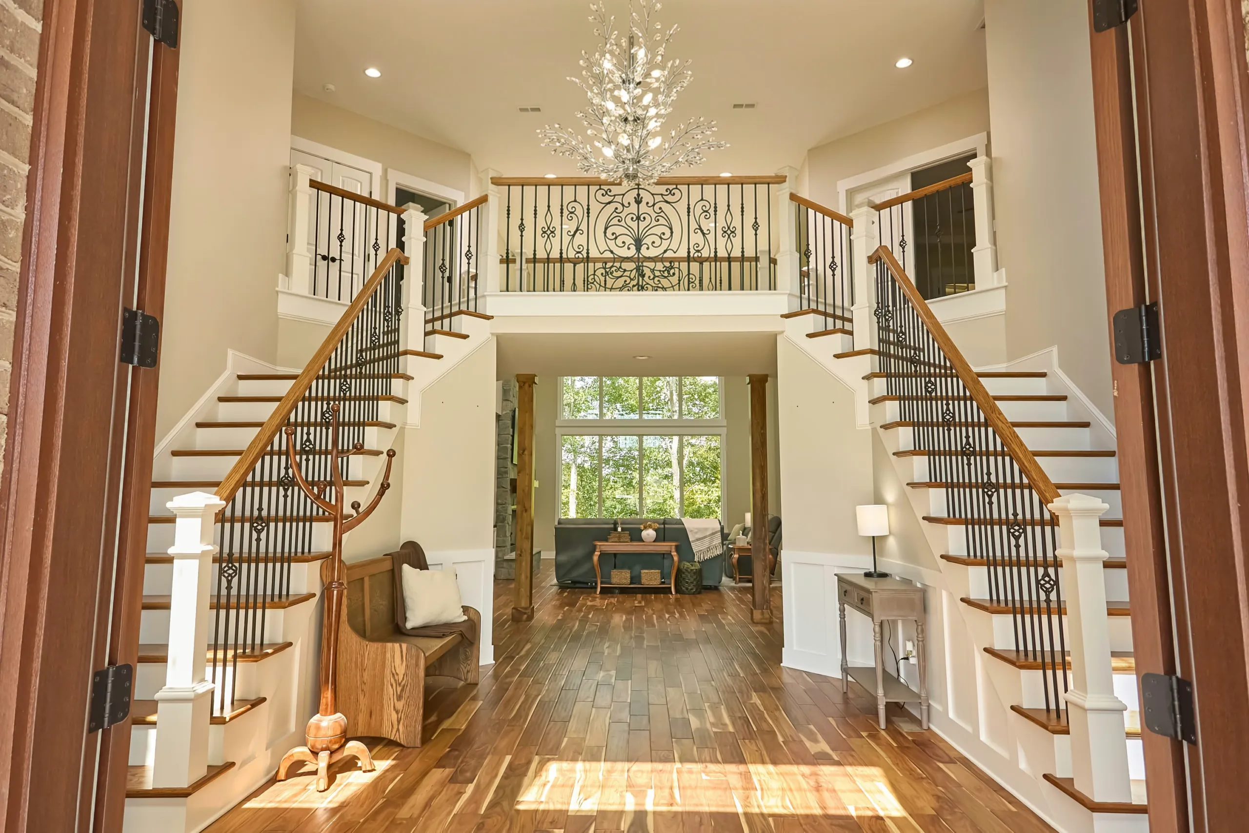 Double staircase and chandelier in the Cedar Fox Home foyer