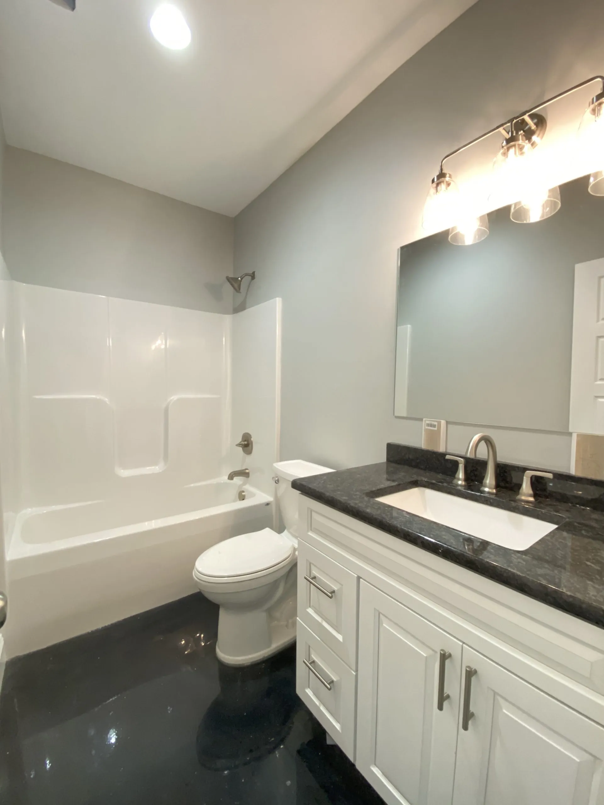 Bathroom with white vanity, granite top and tub-shower in the Falling Creek Home