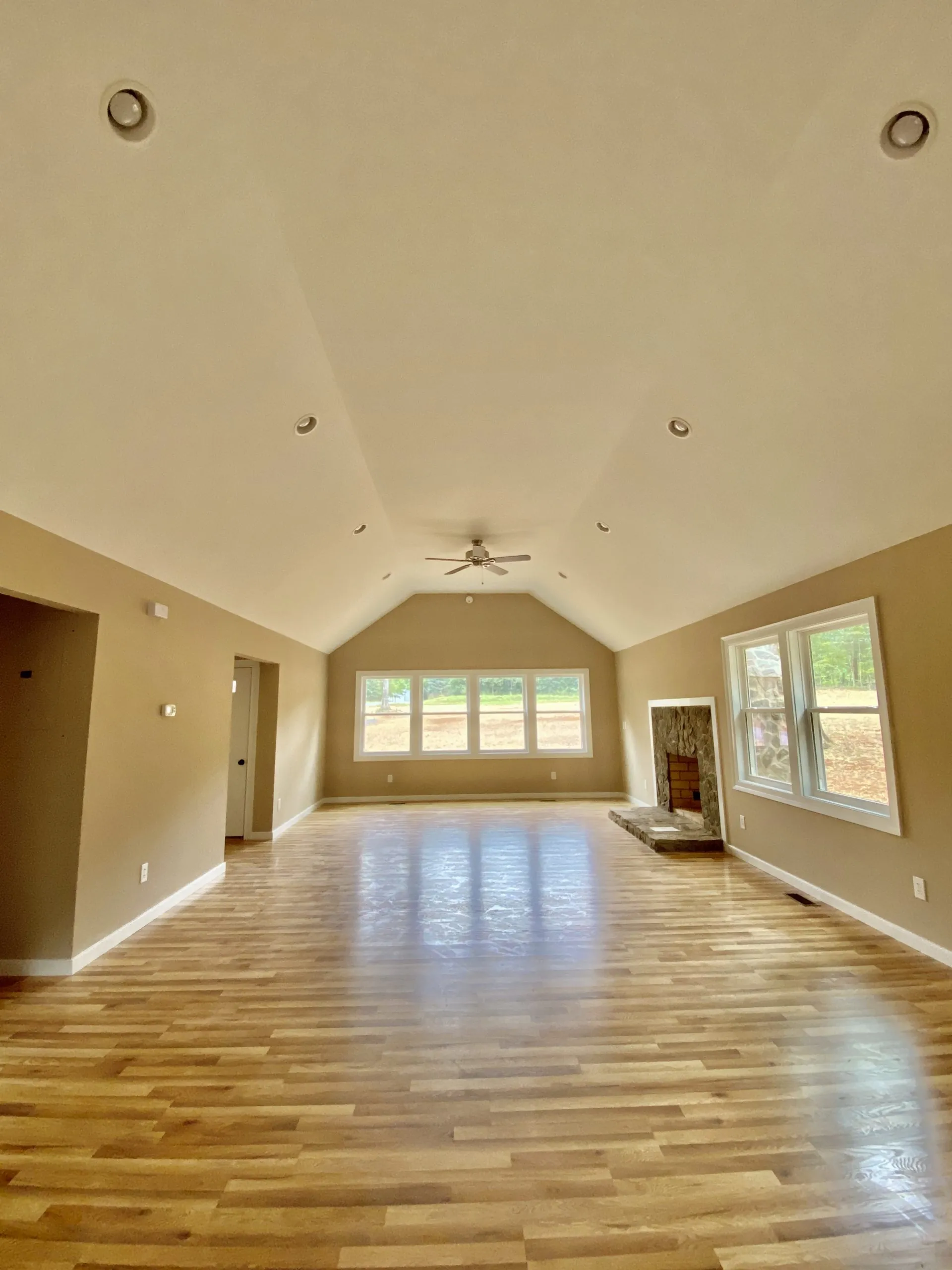 Vaulted living room with hardwood floors and stone fireplace in the Forest Home