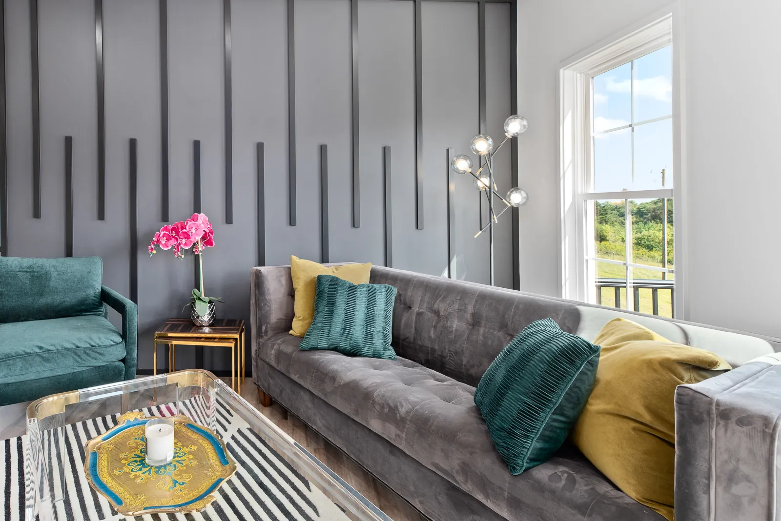 Living room with accent wall and green velvet chair in the Otter River Home
