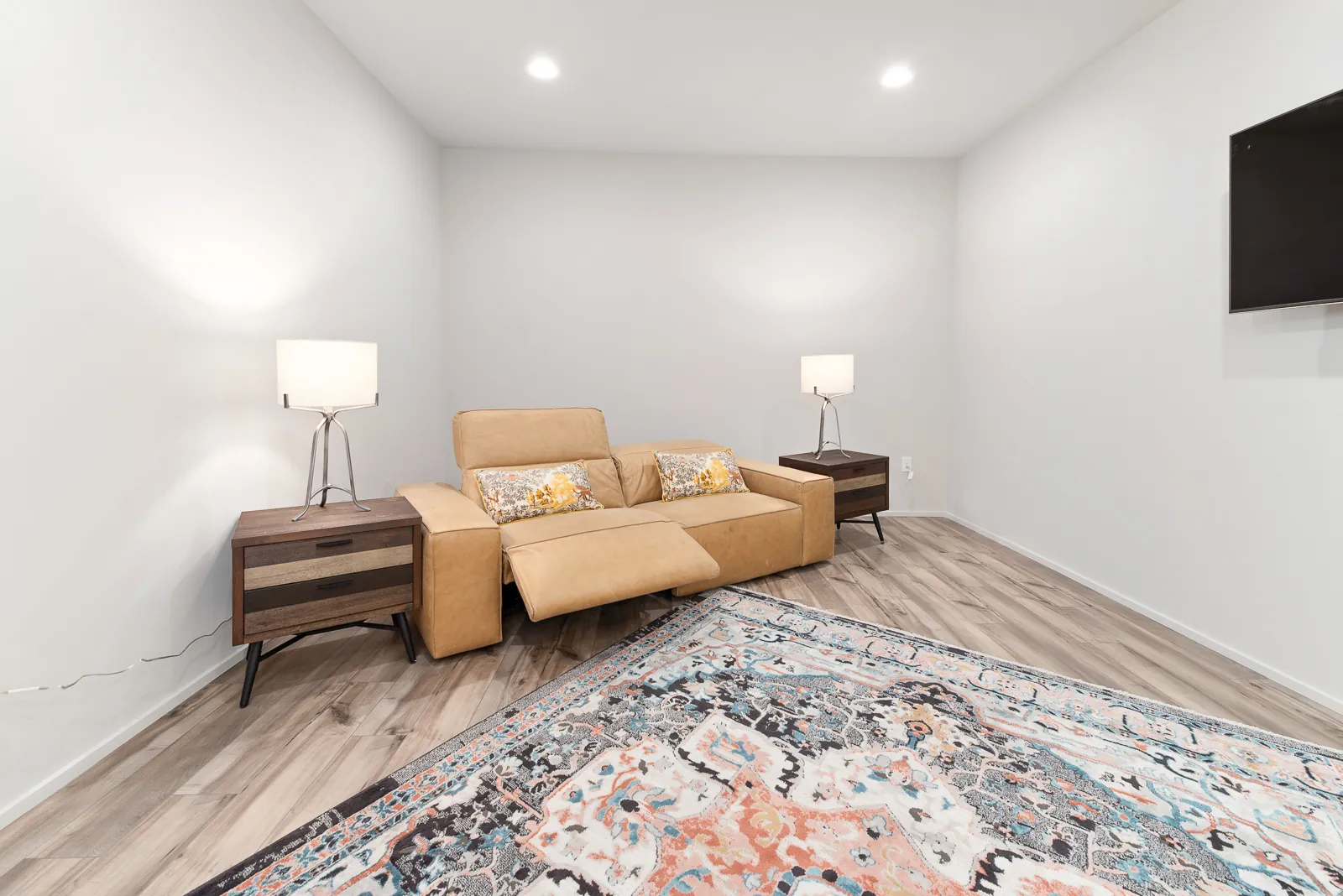 Family den with leather sofa and area rug in the Otter River Home