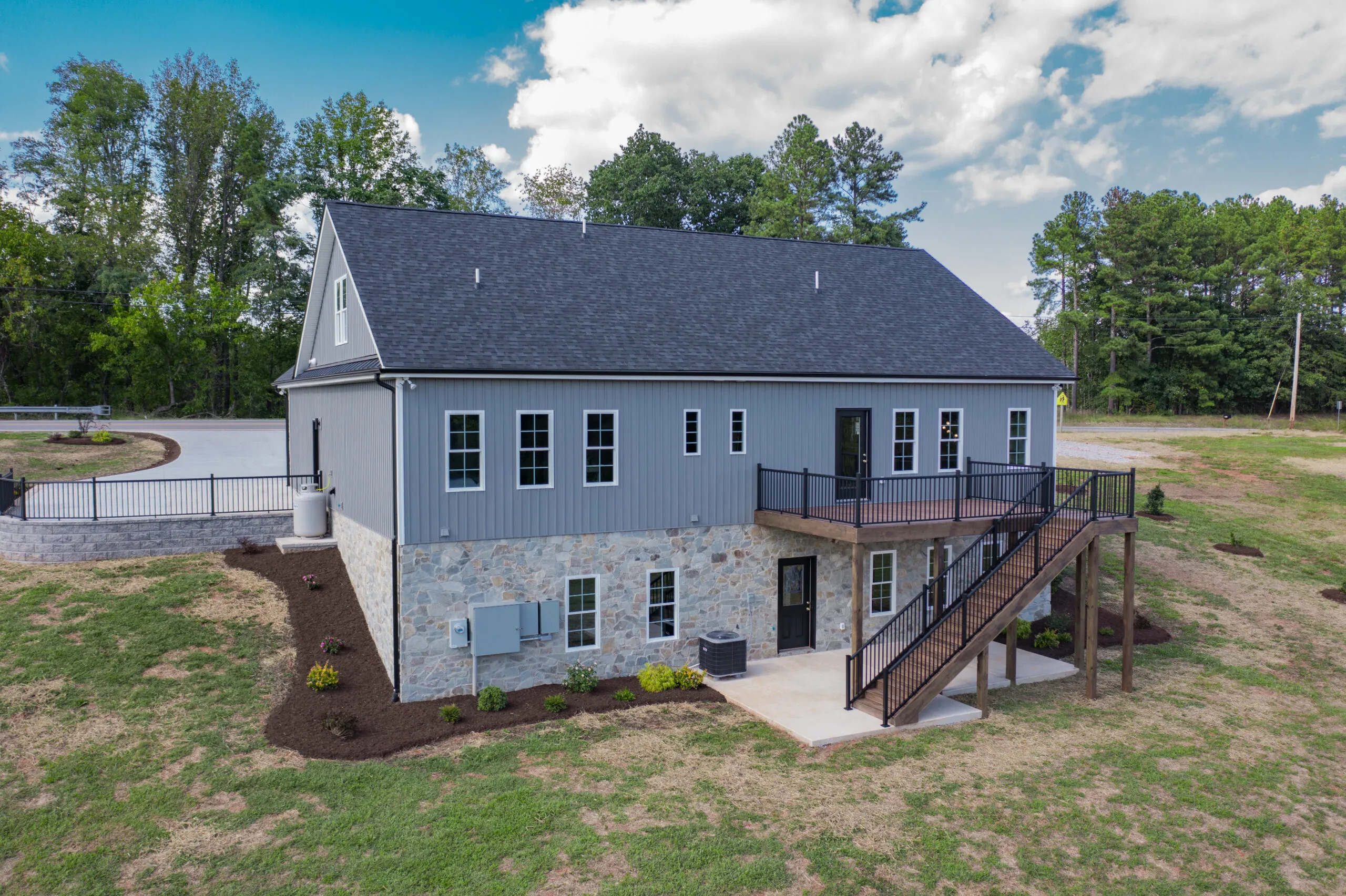 Rear of the Otter River Home with stone foundation and deck stairs