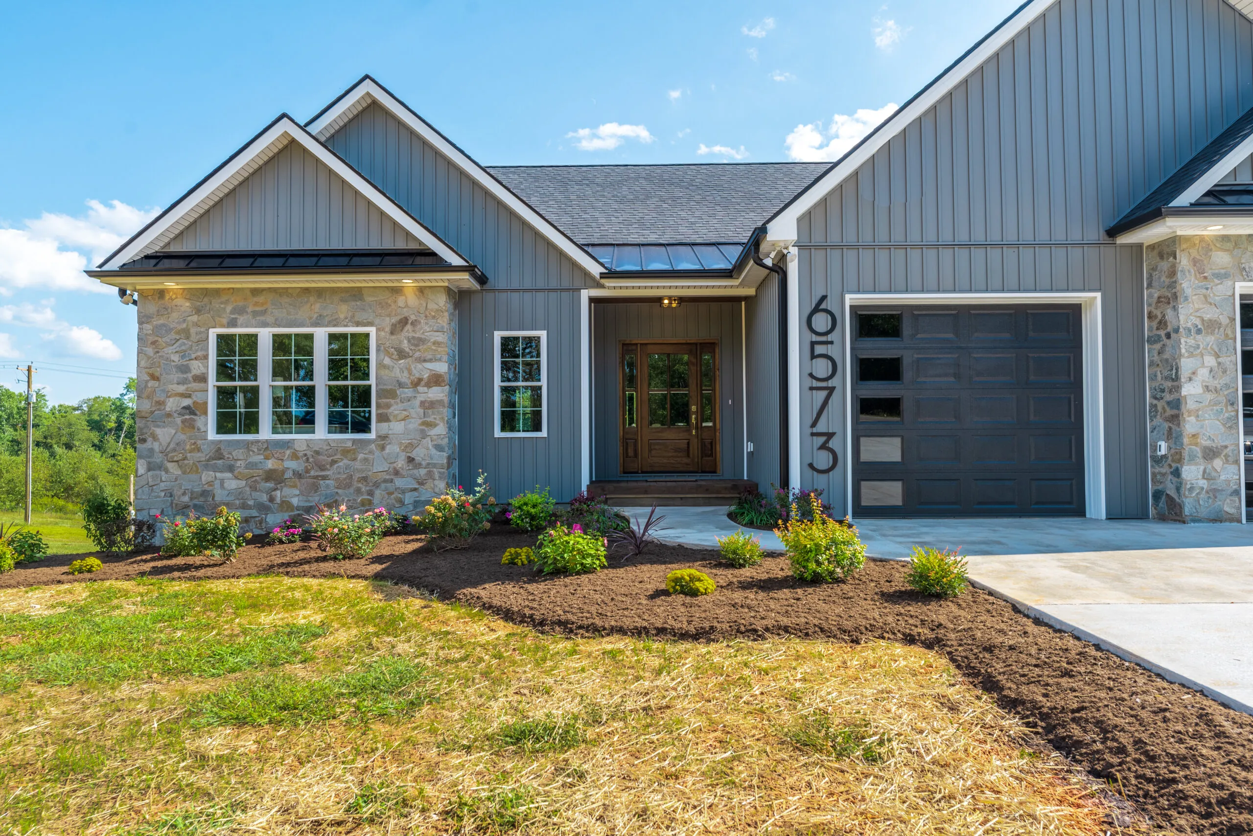 Front entry of the Otter River Home with stone accent and wood door