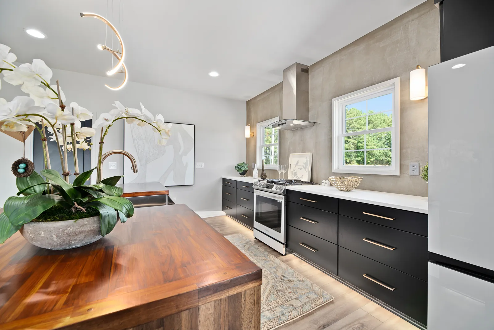 Kitchen with walnut island and black cabinets in the Otter River Home