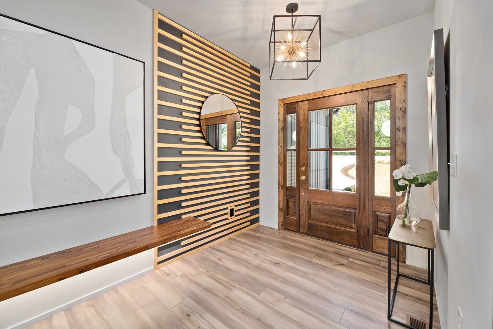 Entry with wood slat accent wall and wood front door in the Otter River Home
