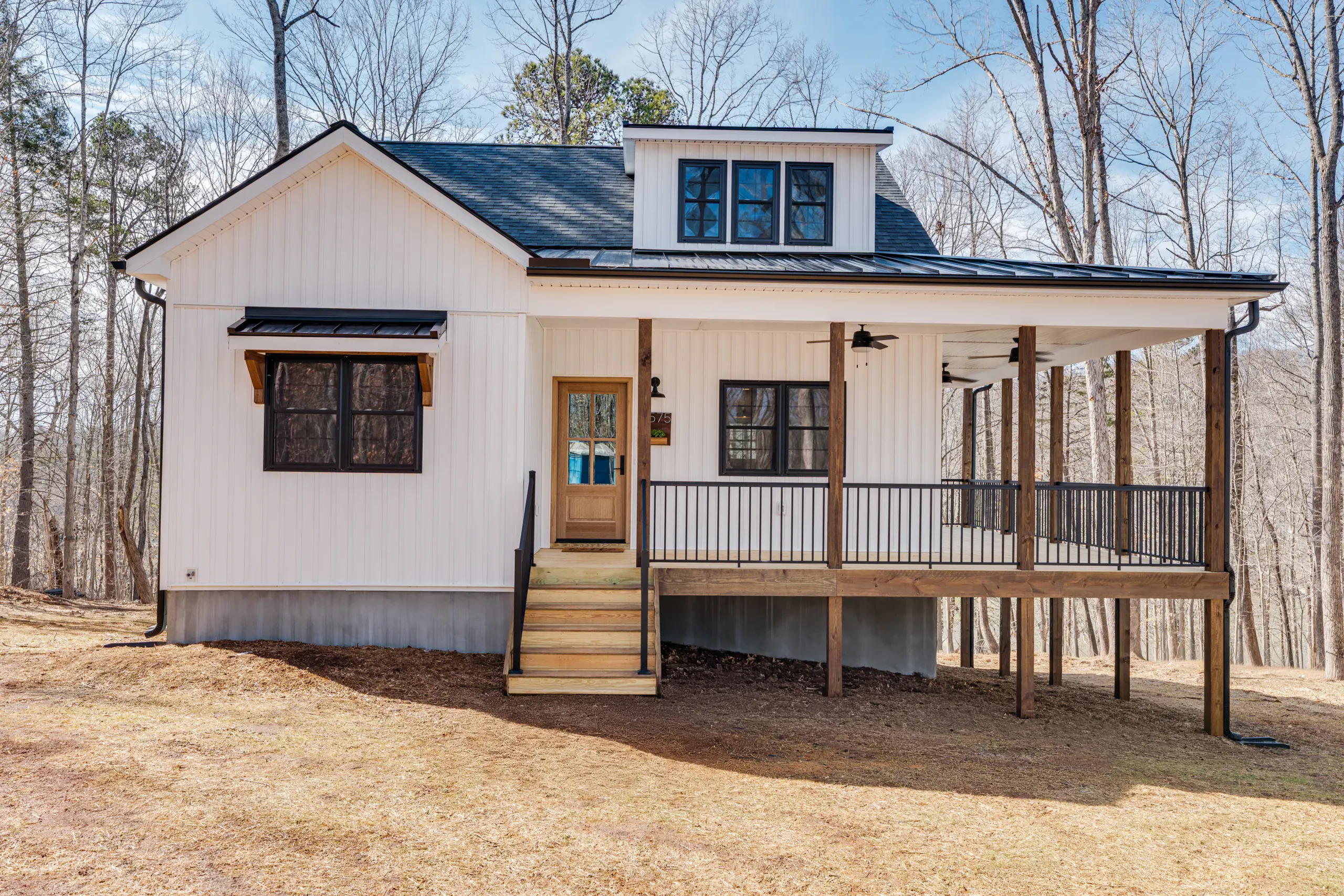 Front of the Reservoir Home with covered porch, wood steps and board-and-batten siding