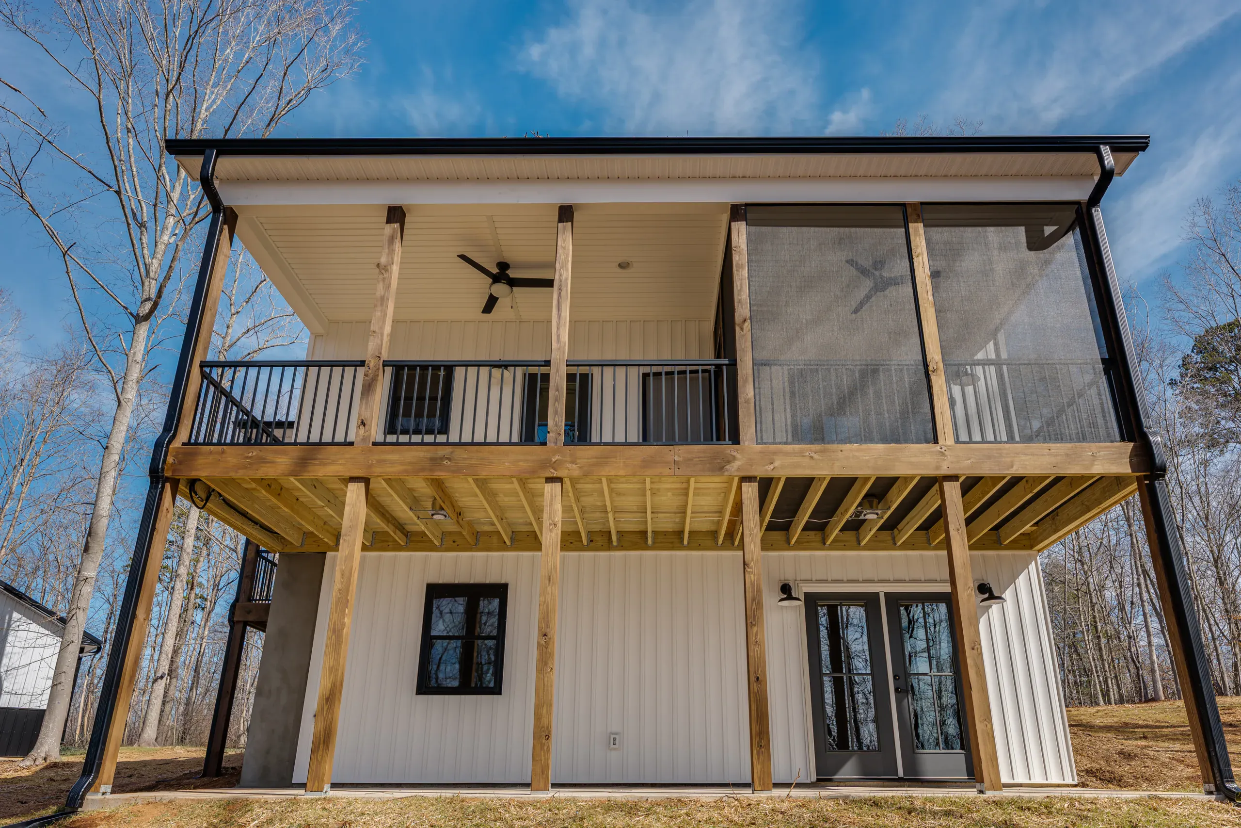 Rear of the Reservoir Home showing screened porch above covered lower deck