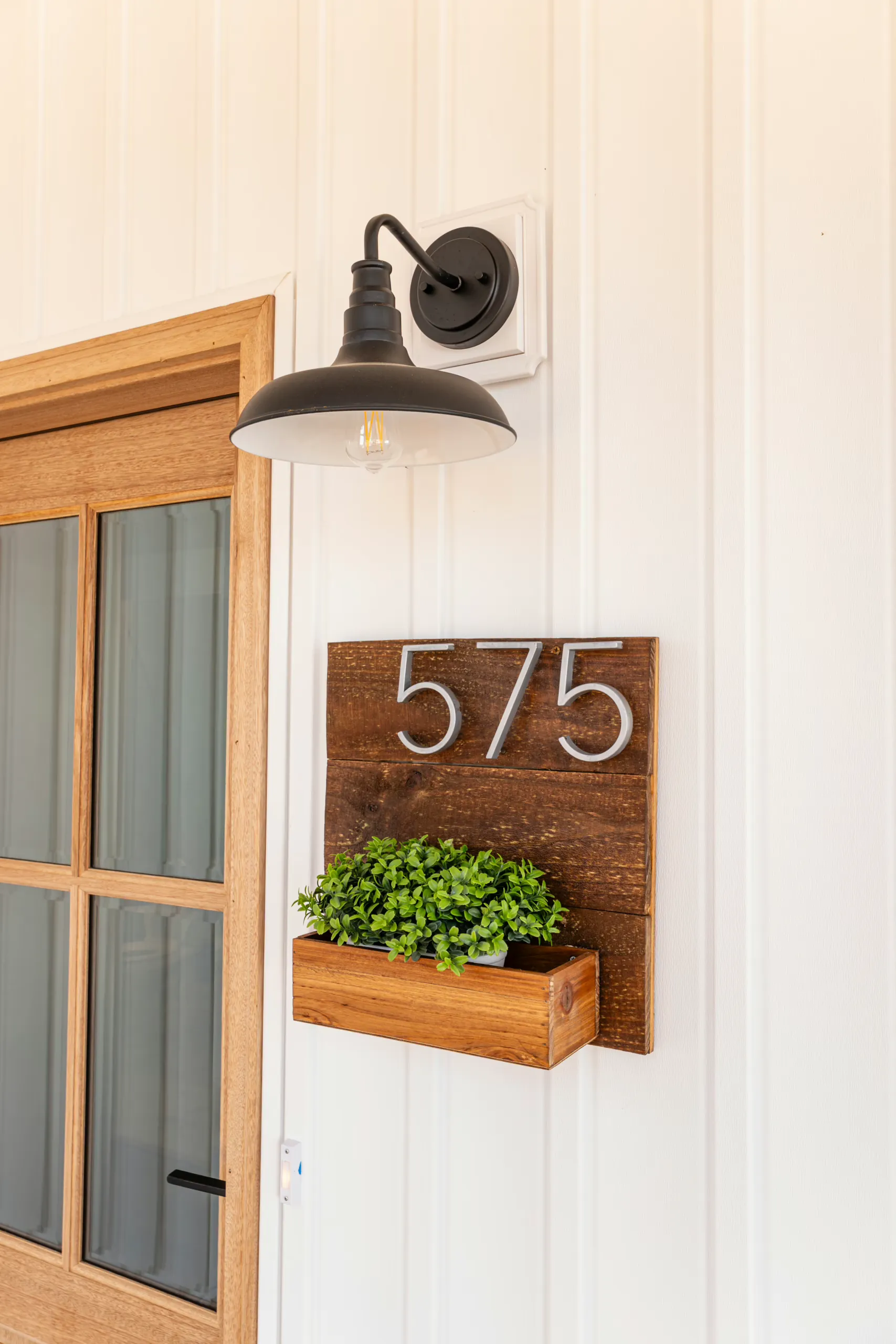 Decorative house number and black barn light beside the front door of the Reservoir Home