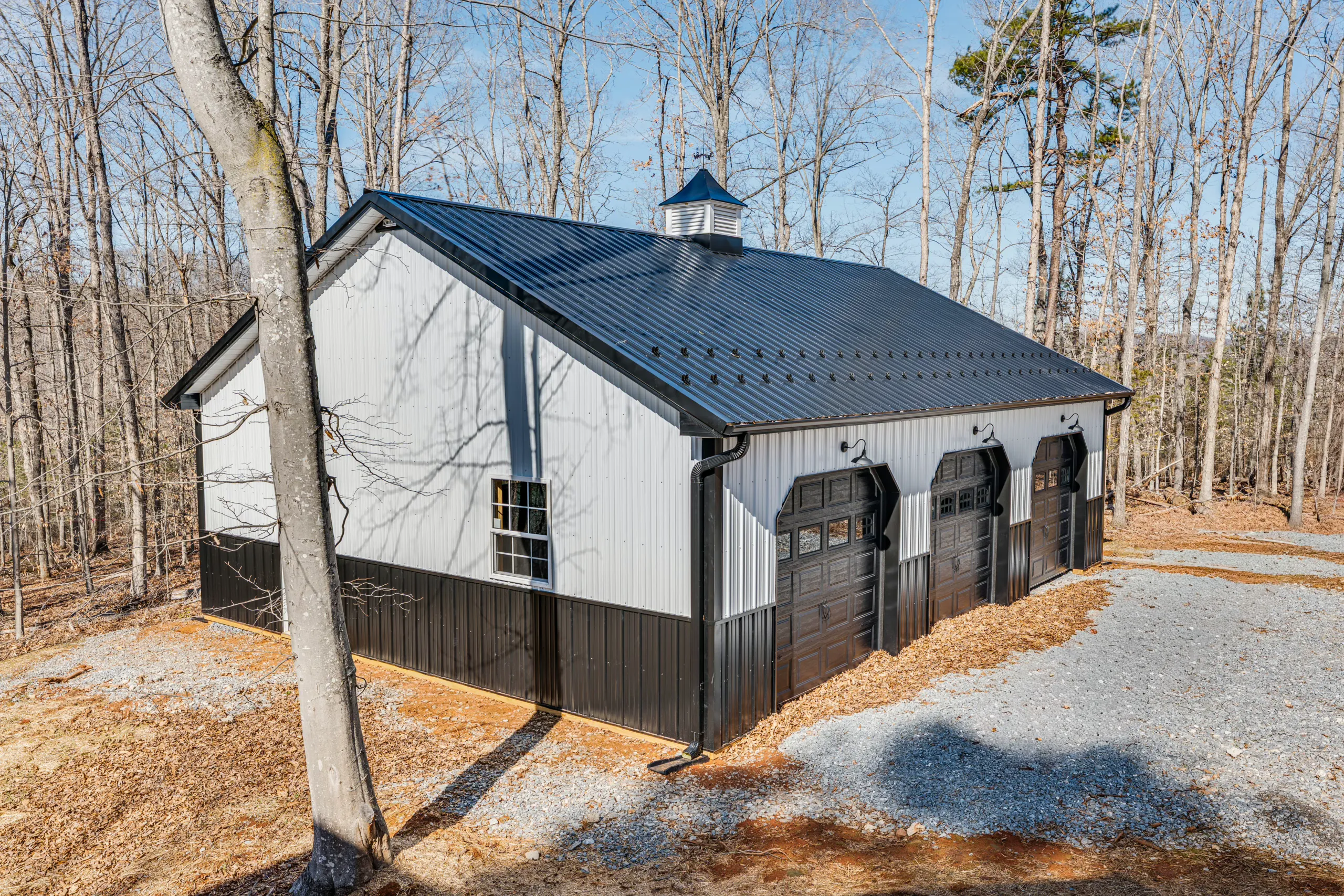 Detached three-car garage with black metal roof at the Reservoir Home