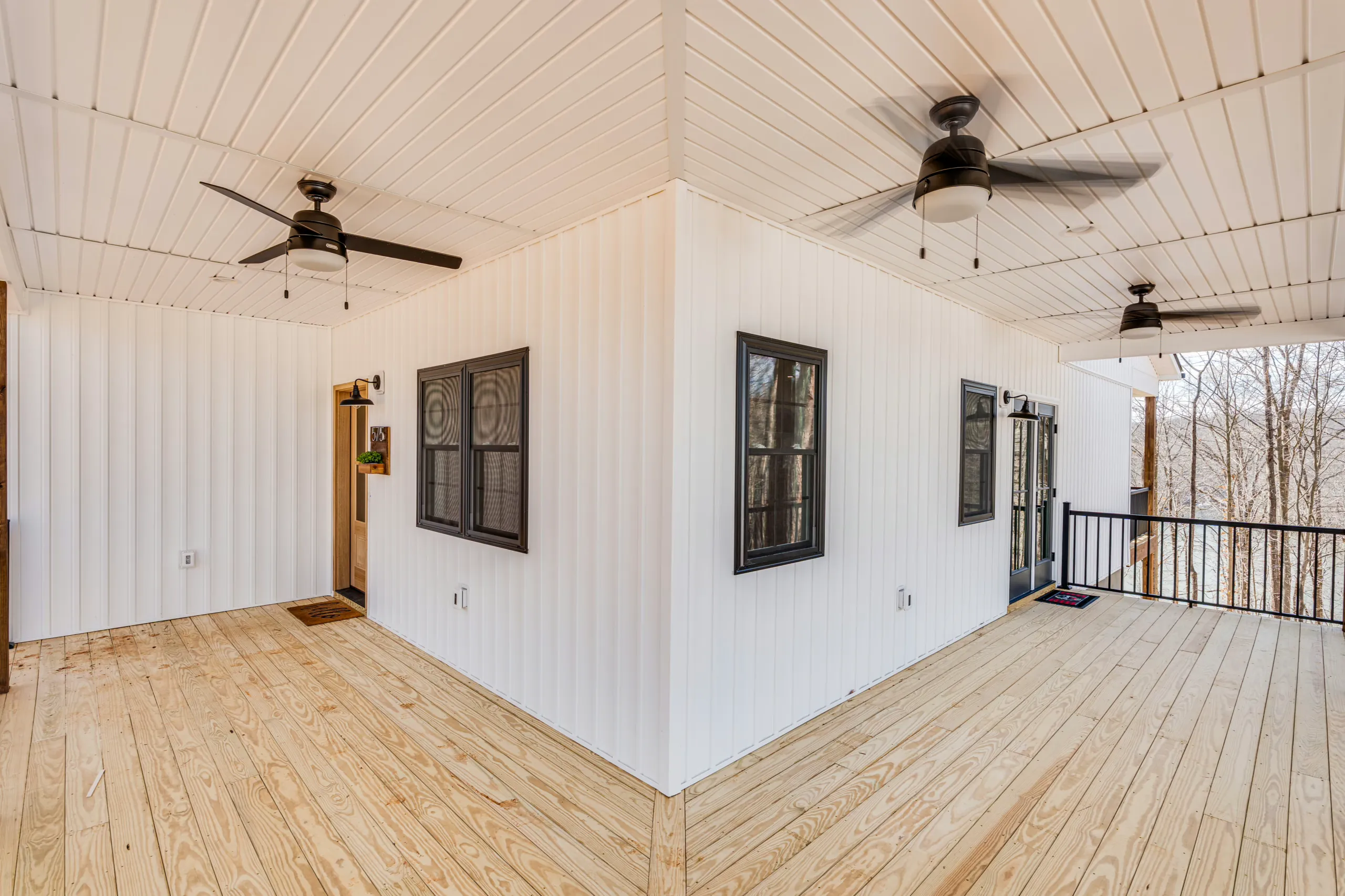 Wraparound covered porch with ceiling fans and wood plank deck at the Reservoir Home
