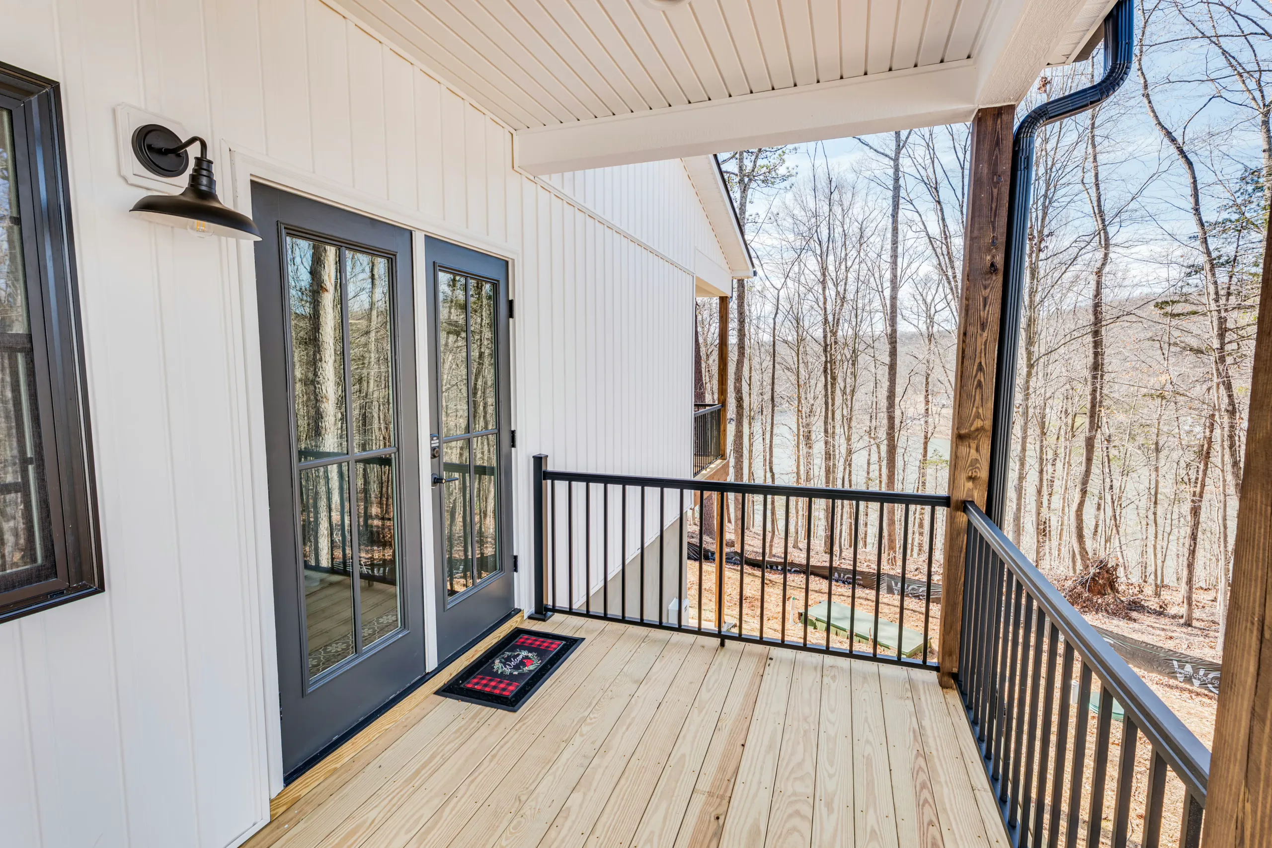 Back porch with gray French doors and black railing at the Reservoir Home