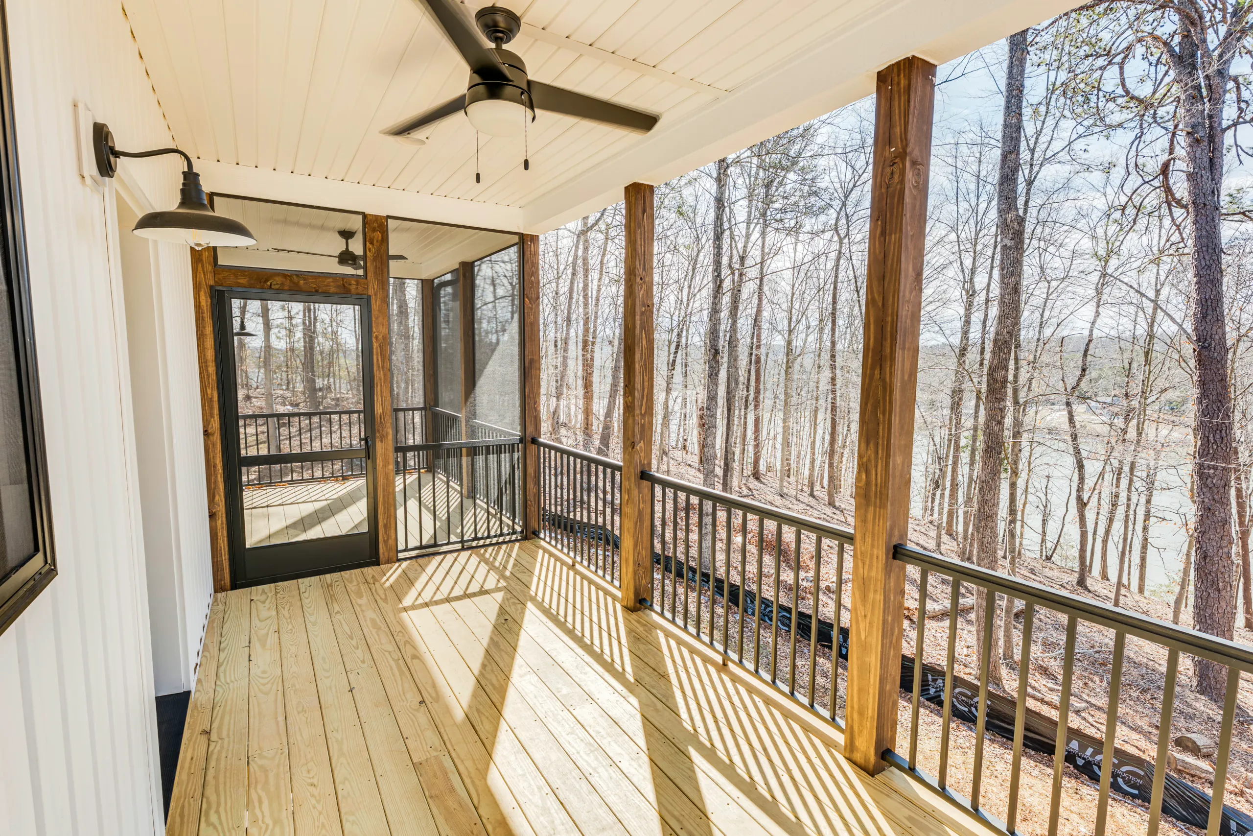 Covered rear porch with screen door and ceiling fan at the Reservoir Home