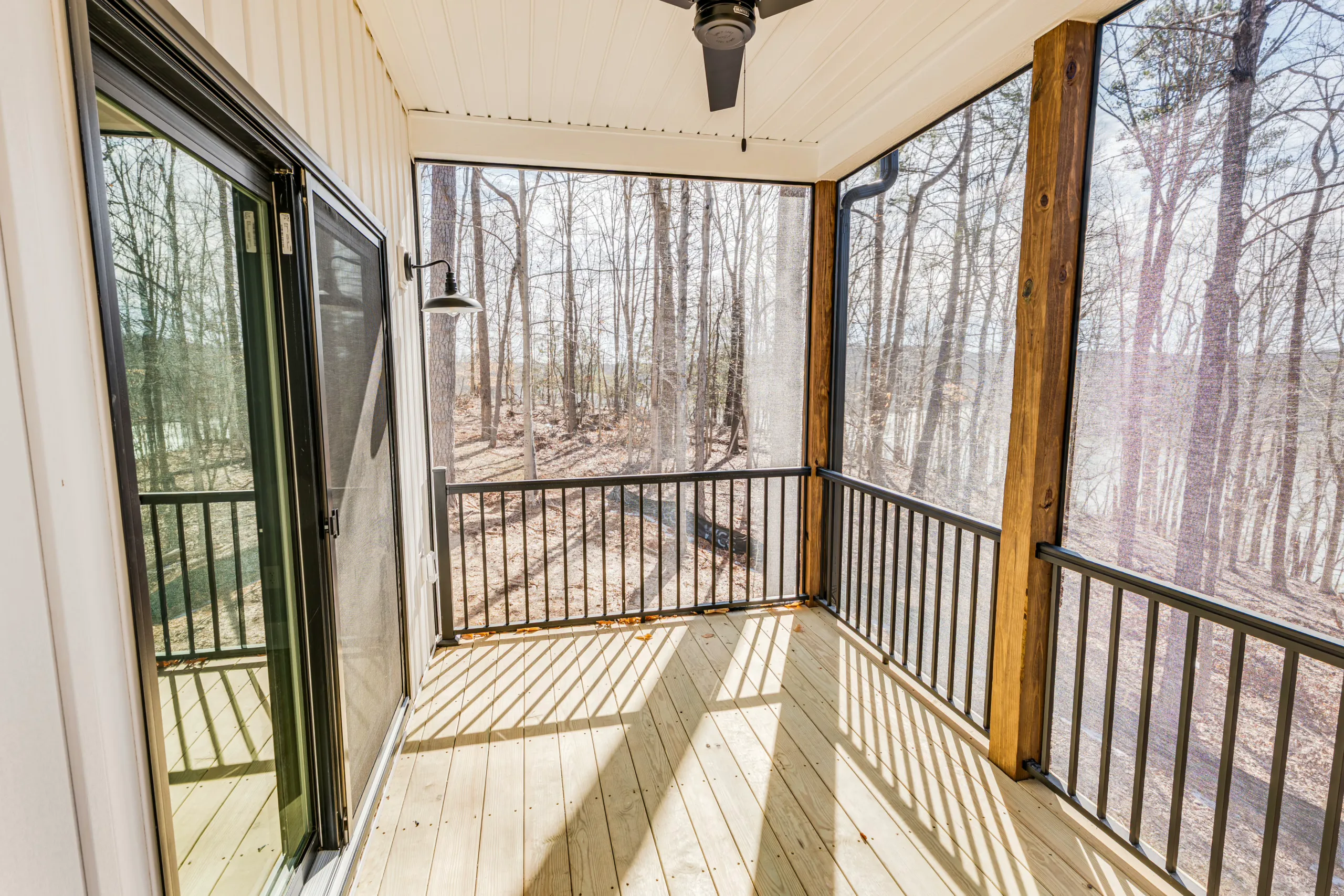 Screened porch with sliding door and wooded view at the Reservoir Home
