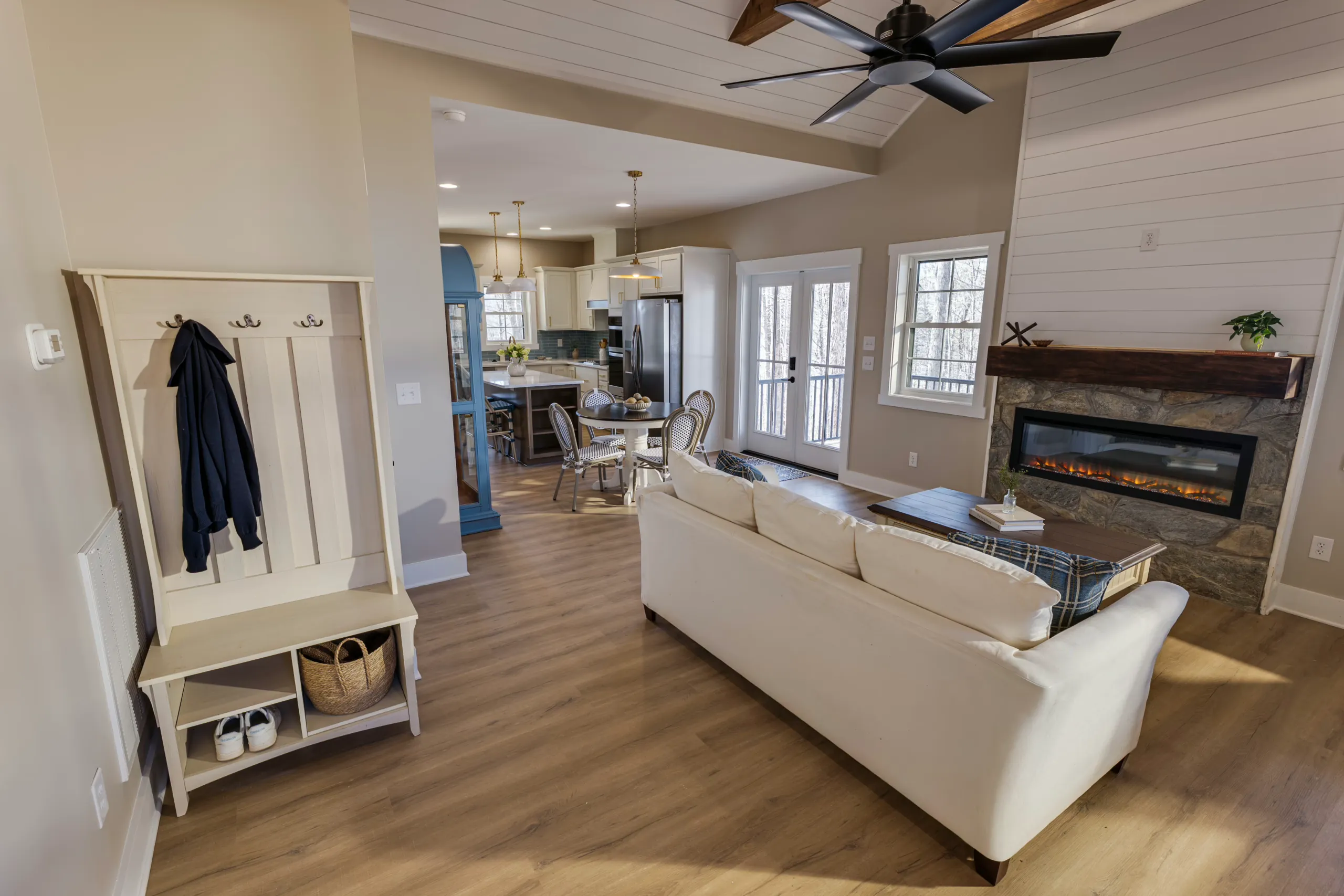 Living room with linear fireplace and entry bench opening to kitchen in the Reservoir Home