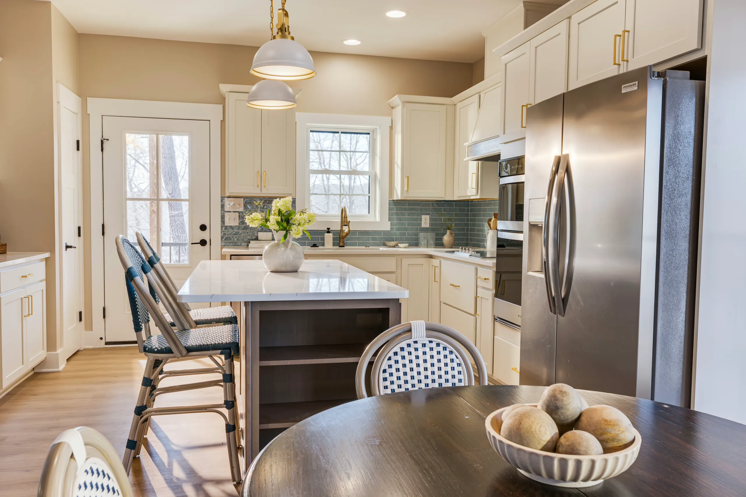 Kitchen island with woven stools seen from the dining table in the Reservoir Home
