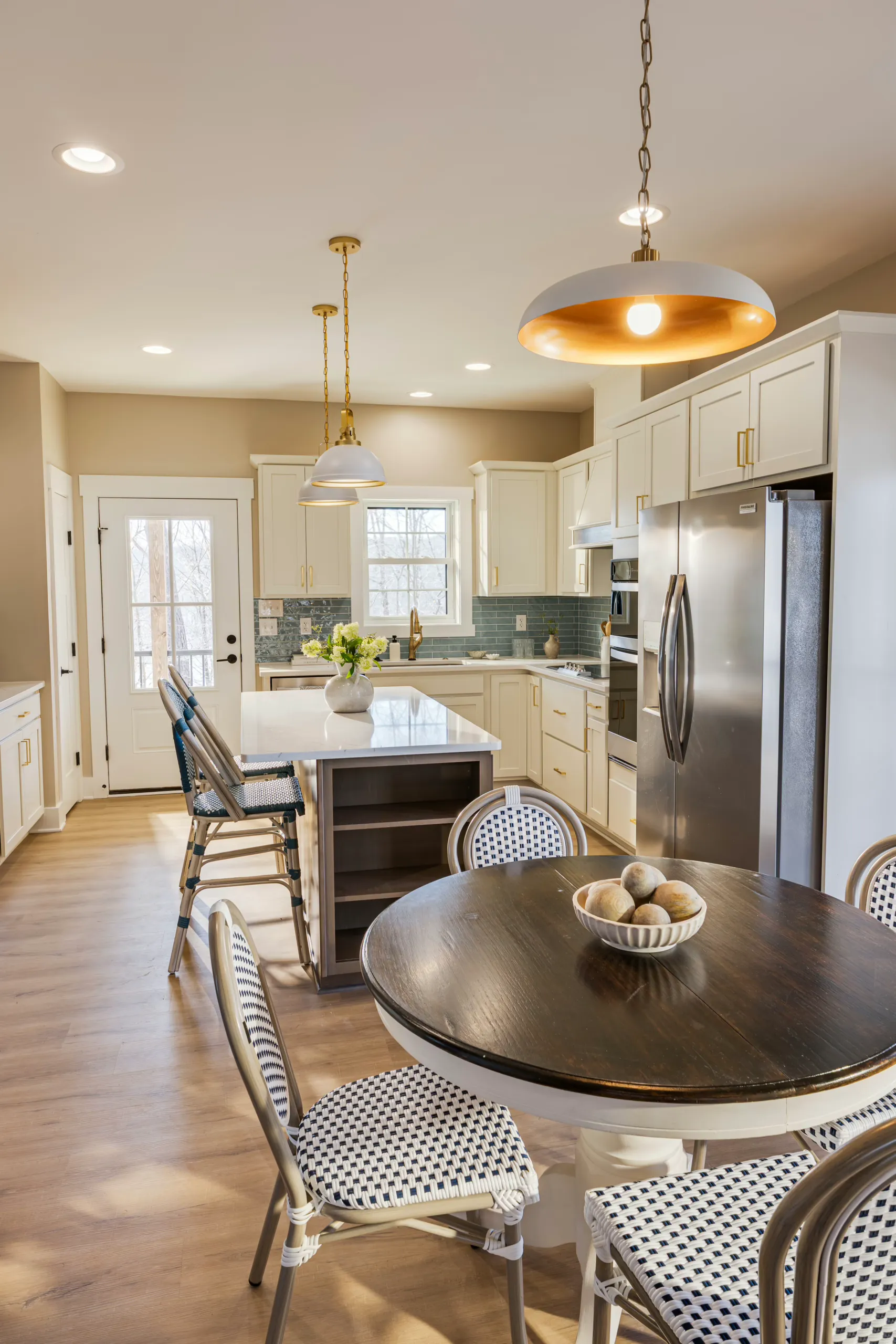 Kitchen and dining area with white cabinets and round table in the Reservoir Home