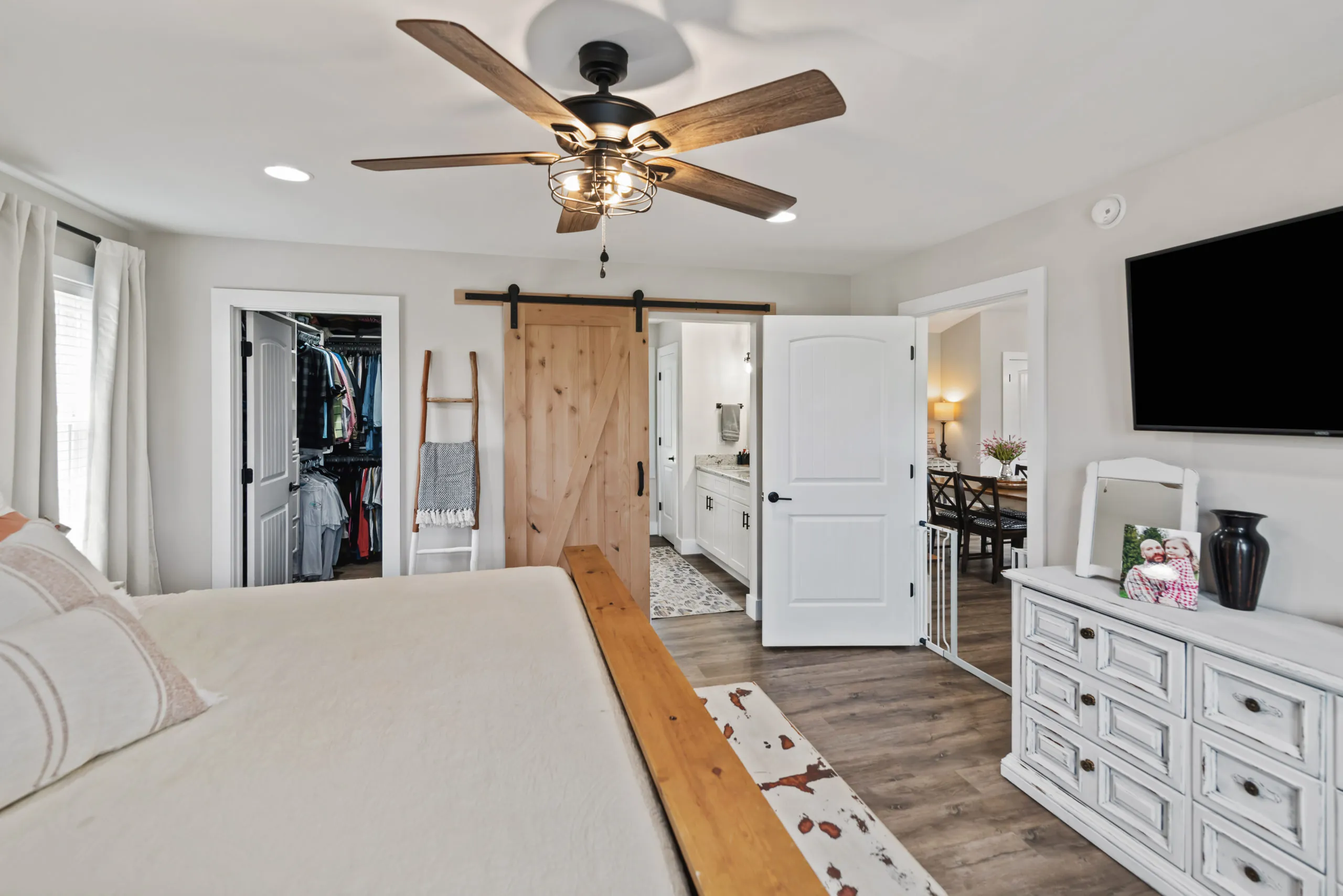 Primary bedroom with barn door to the bath and walk-in closet in the Lake Cross Home