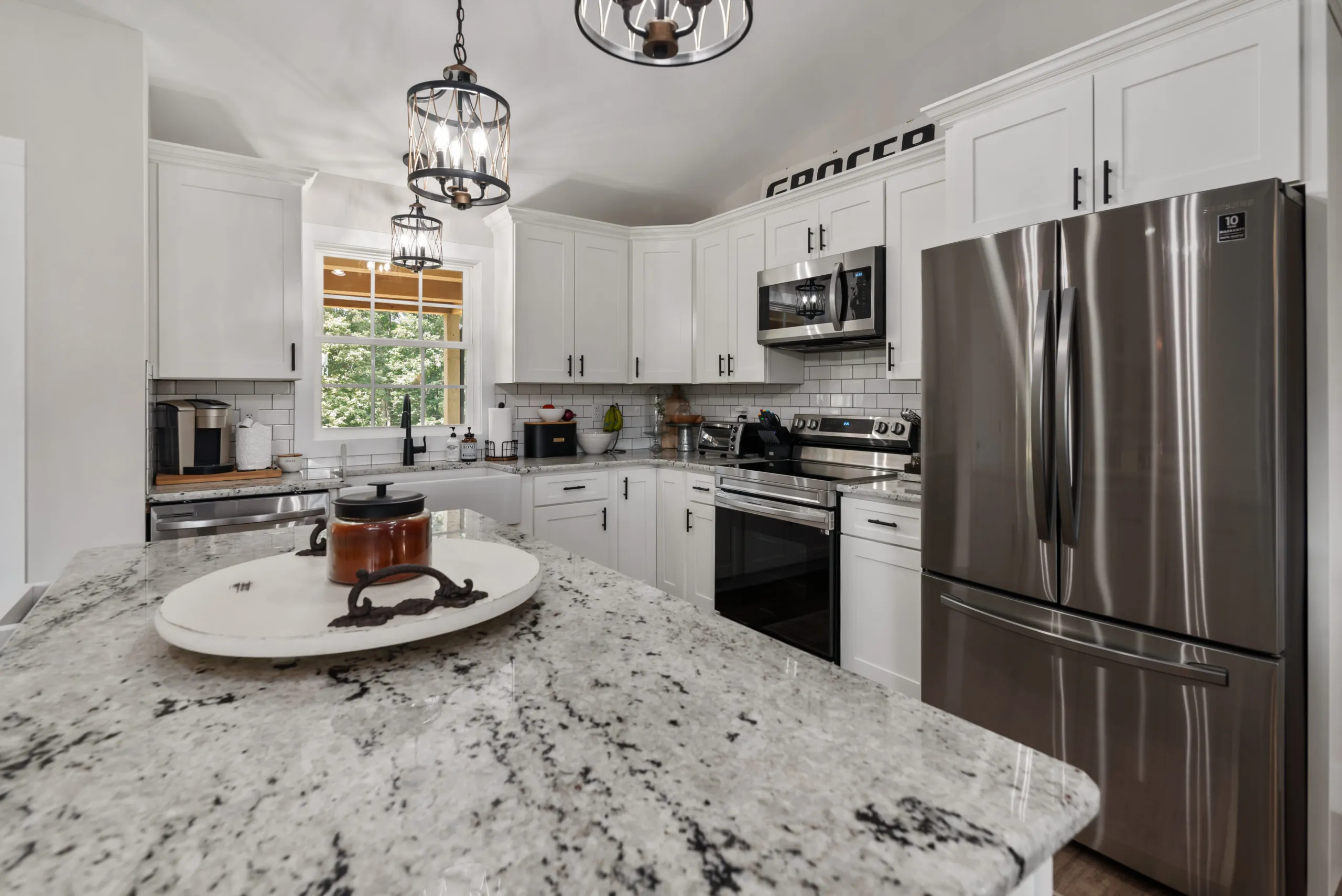 White kitchen with granite island and stainless appliances in the Lake Cross Home