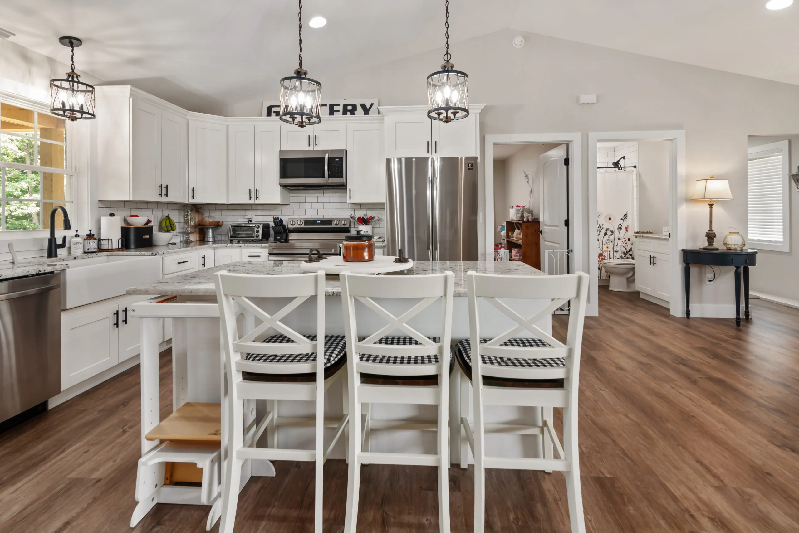 Kitchen island with bar stools and pendant lights in the Lake Cross Home
