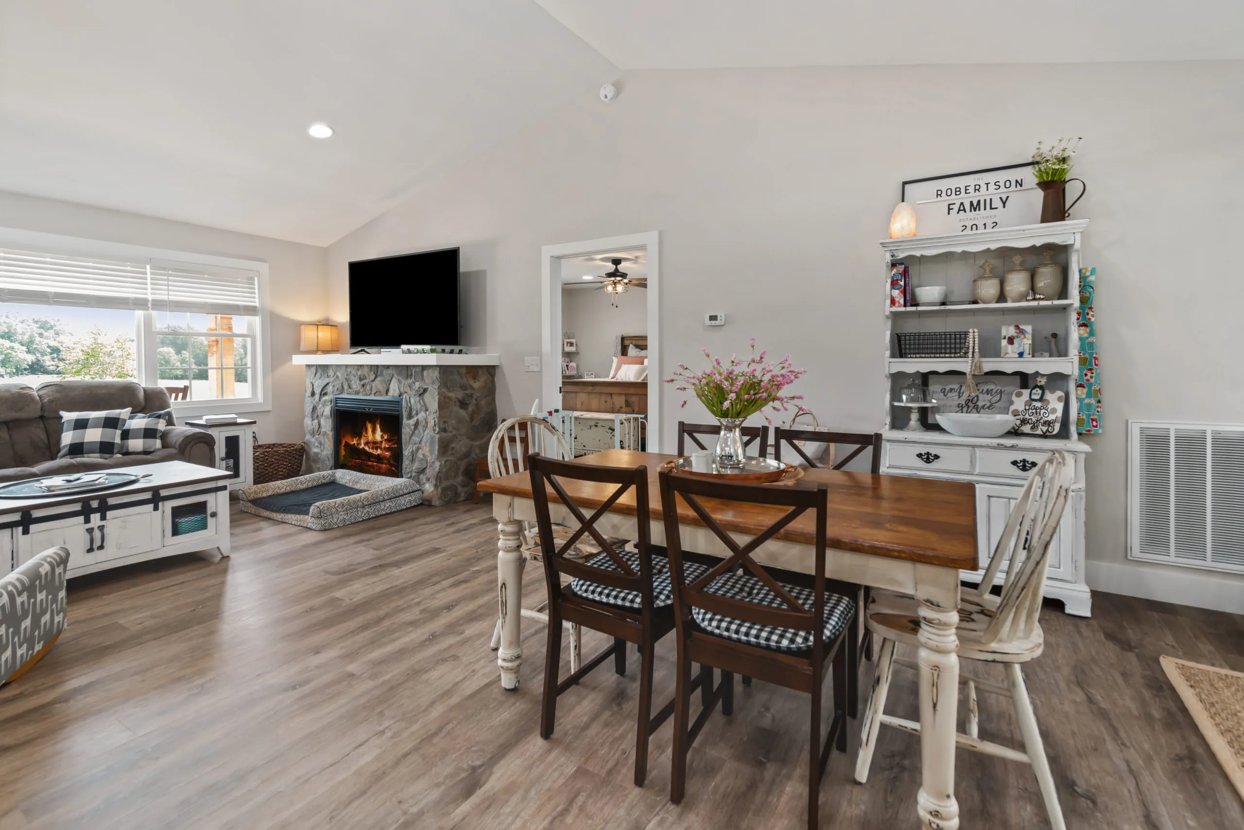 Dining area and stone fireplace in the open living space of the Lake Cross Home