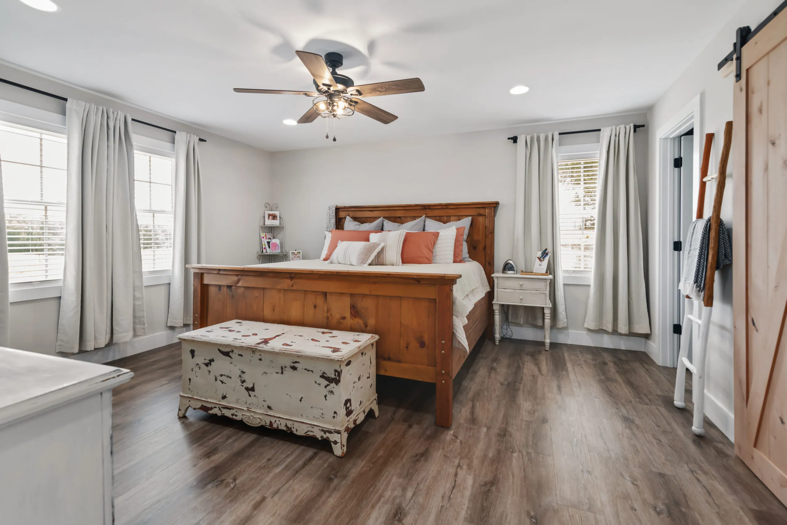 Primary bedroom with wood bed and large windows in the Lake Cross Home