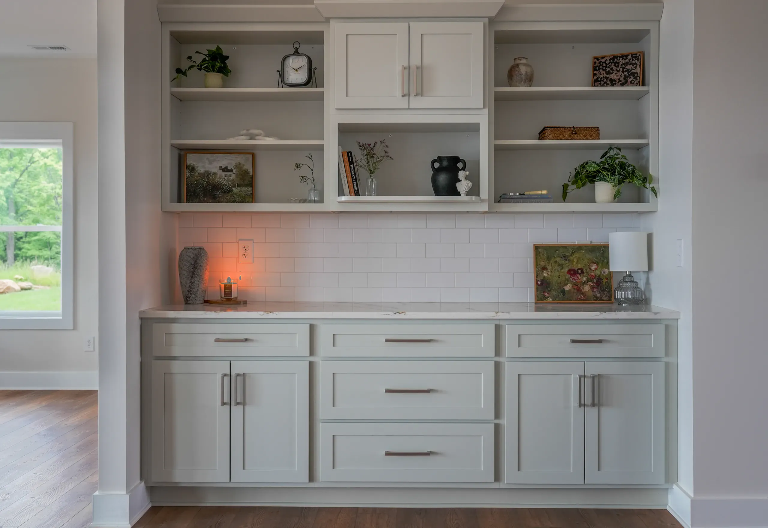 Built-in gray cabinetry with open shelves and white subway tile in the Mountain Crest Home