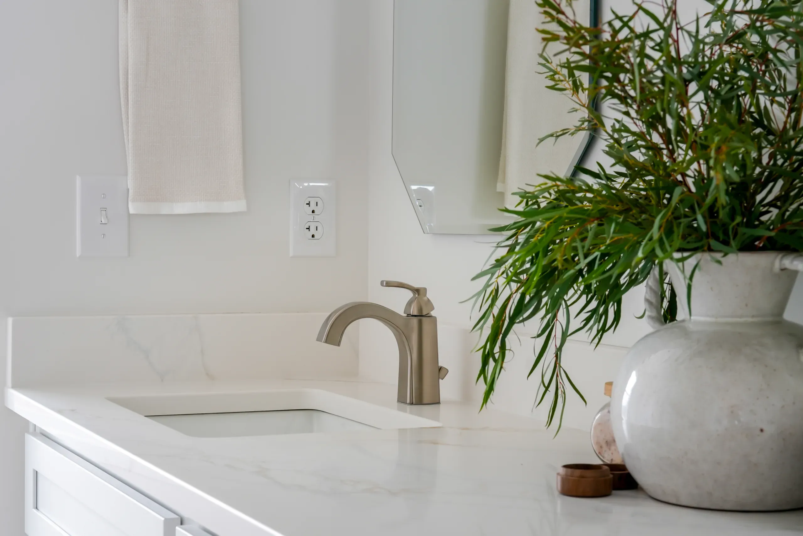 Brushed nickel faucet and quartz counter in the primary bath of the Mountain Crest Home