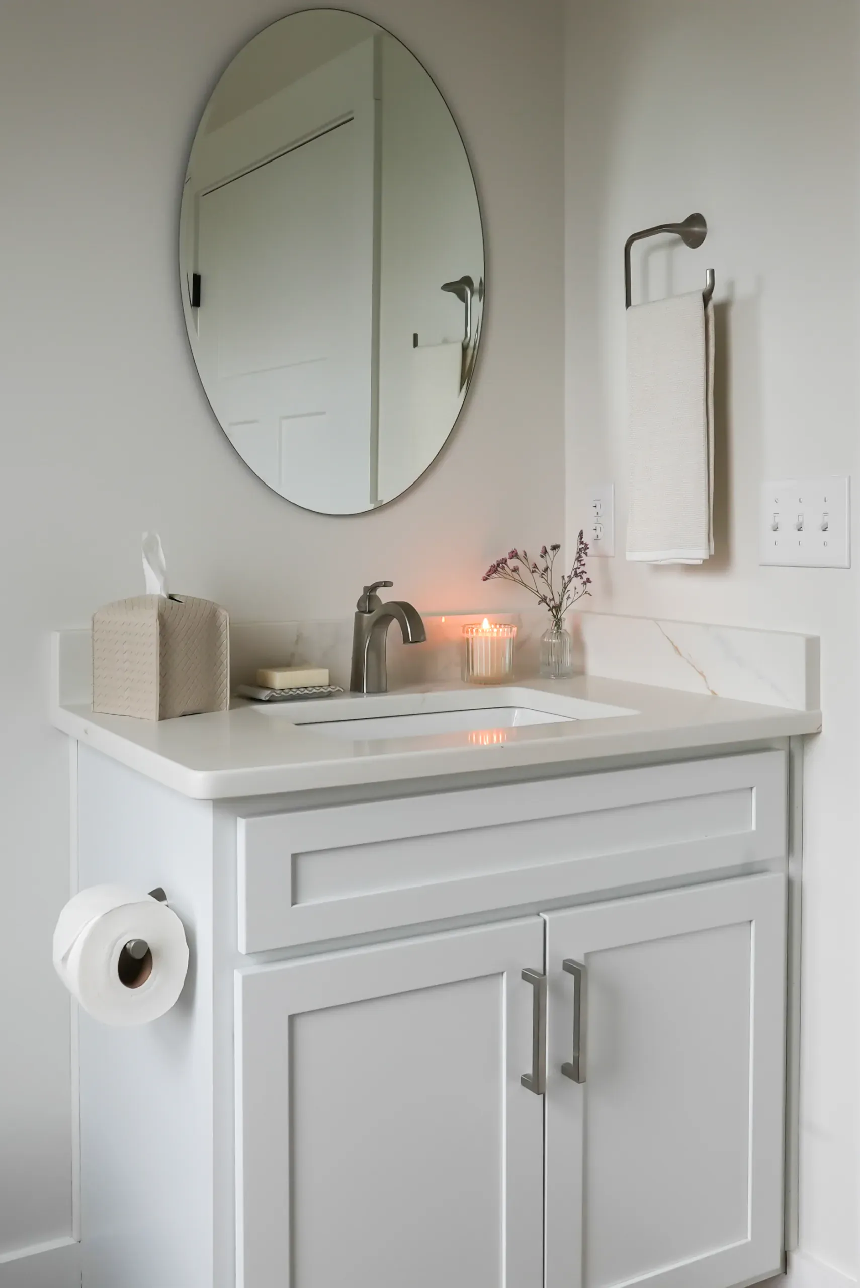 White half-bath vanity with oval mirror in the Mountain Crest Home