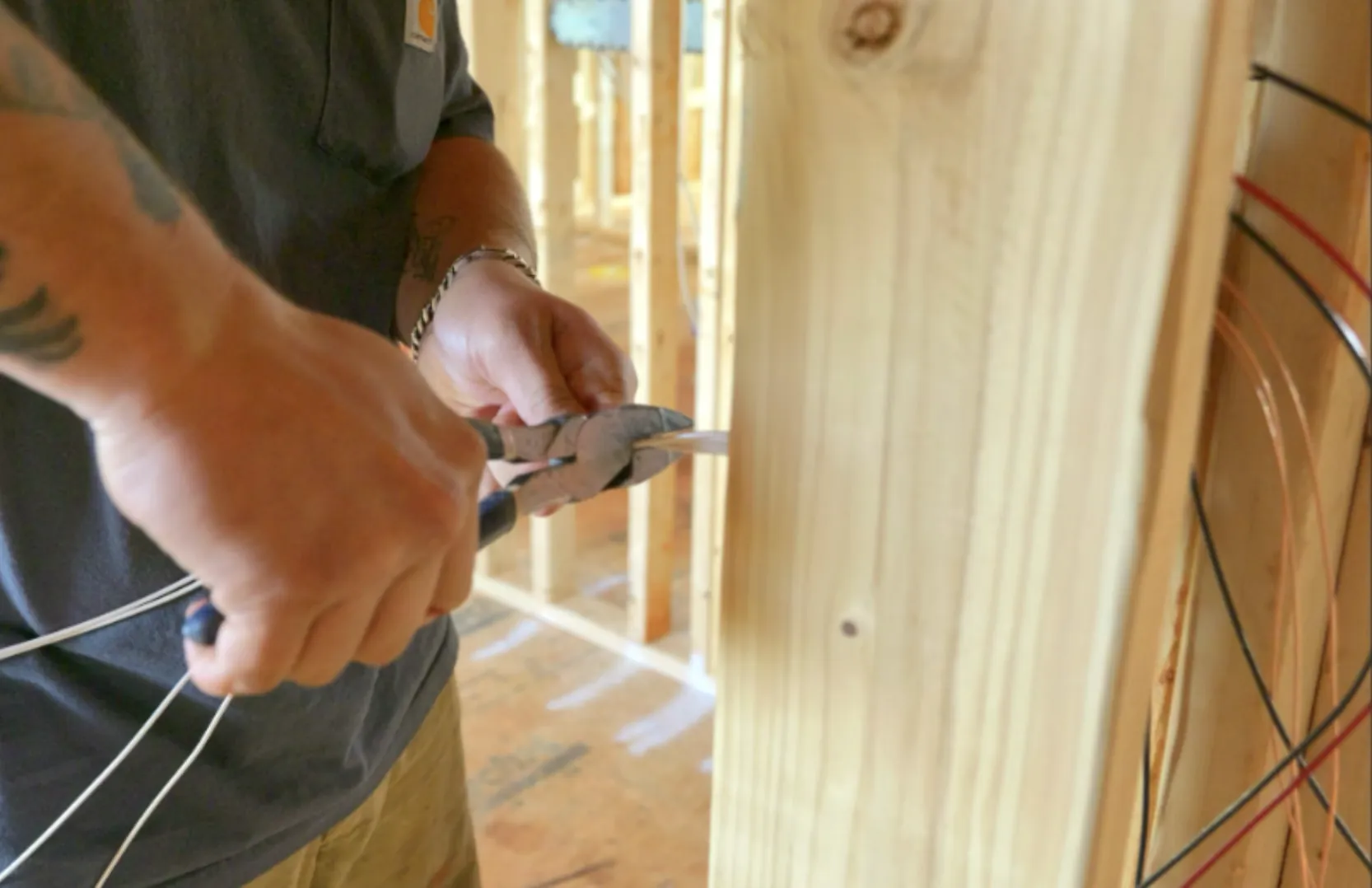 Electrician cutting wires during the construction of a custom home.
