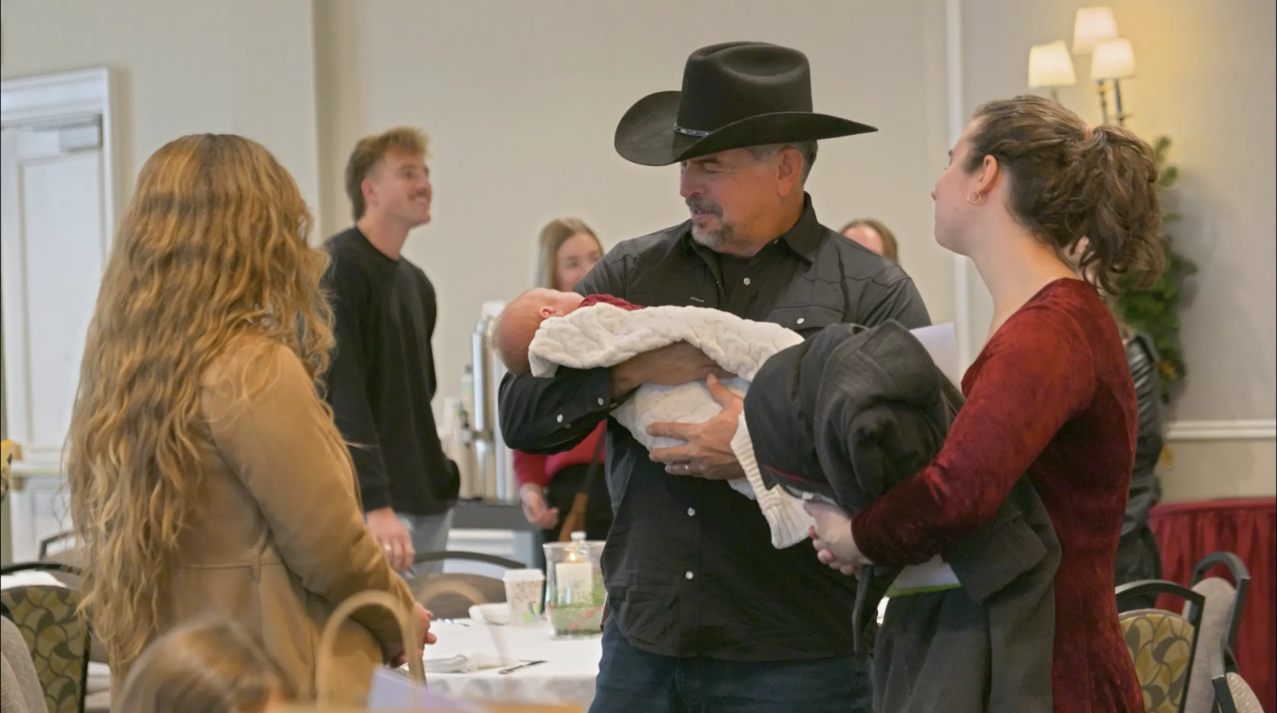 Guests at a Wright Choice event, a man in a cowboy hat holding a baby